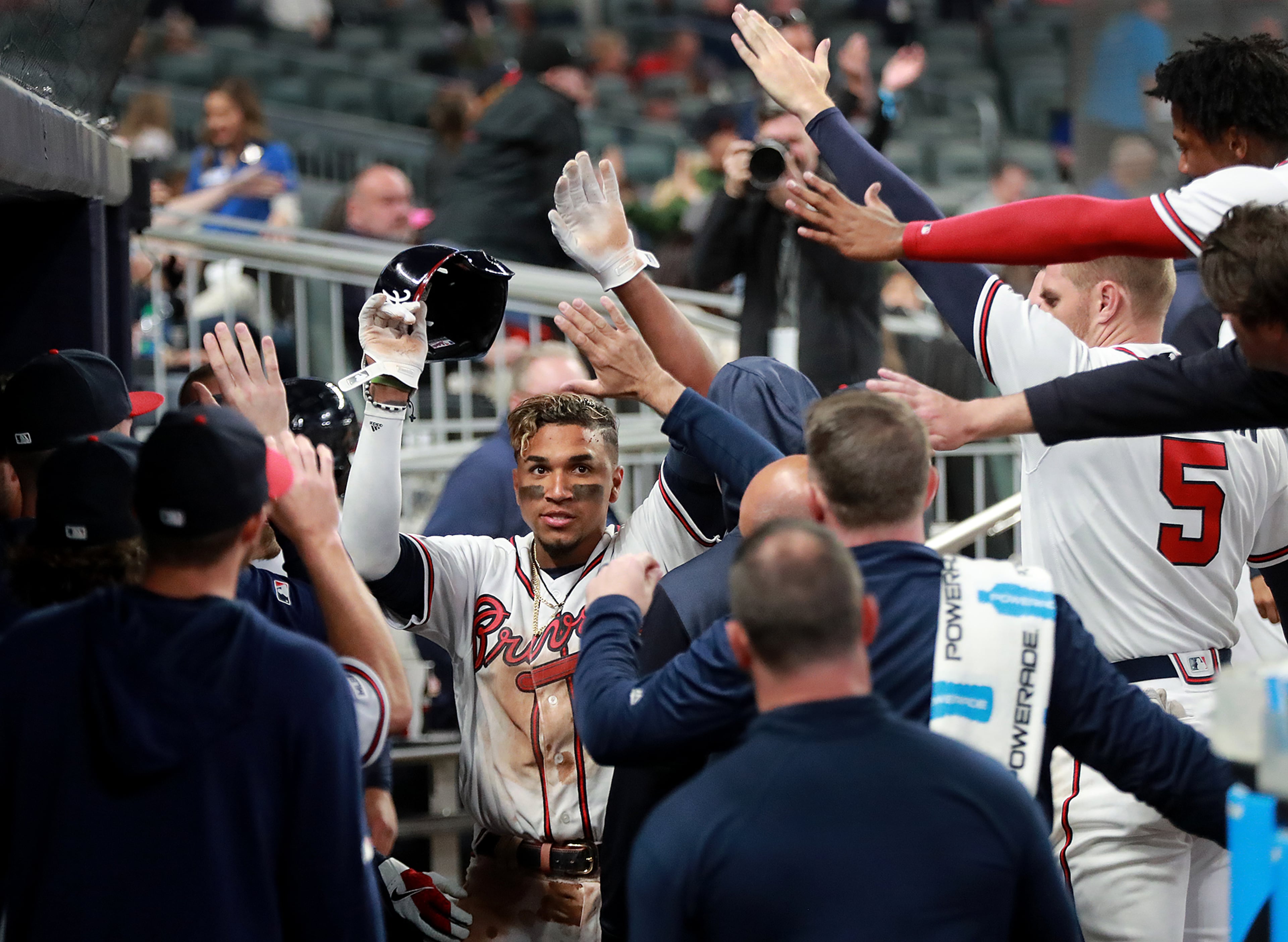 Johan Camargo gets high fives all around in the dugout after scoring. Curtis Compton/ccompton@ajc.com
