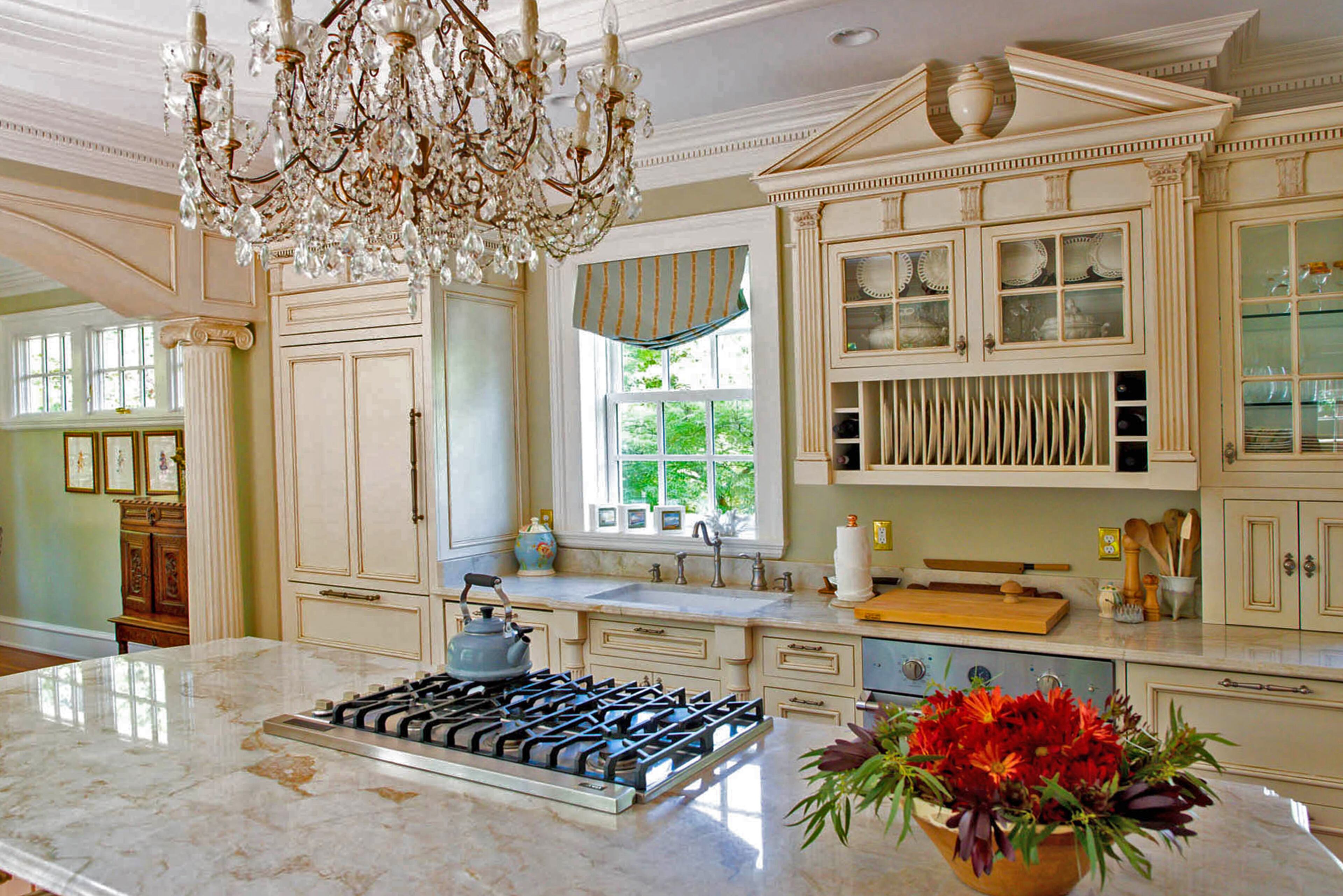 A turn-of-the-century Italian chandelier is a glamorous addition in the renovated kitchen. The countertops are quartzite, and the cabinets were custom built by now-retired David Couture.