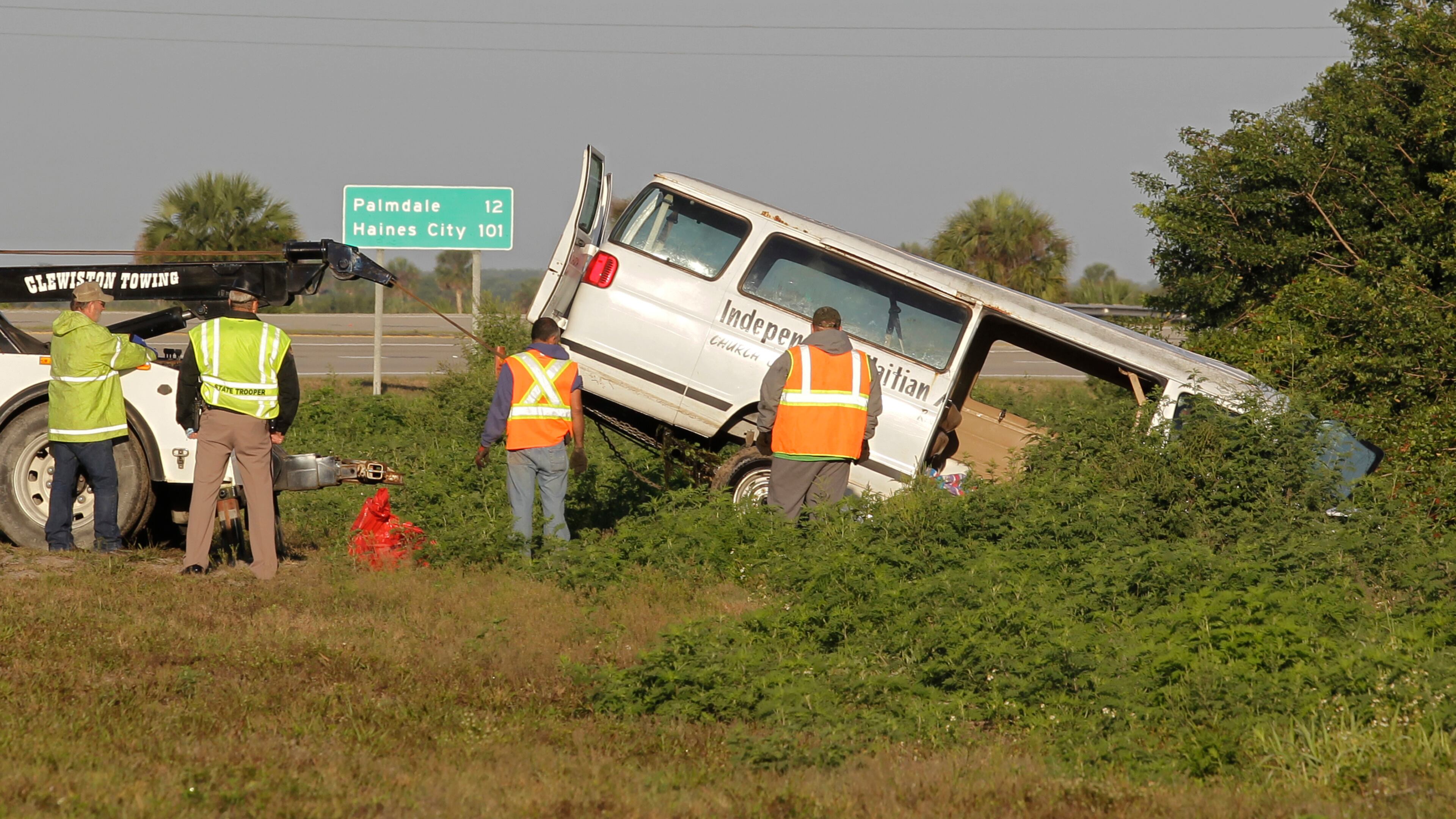 Workers pull a van out of a canal at the intersection of US 27 and State Road 78 West, Monday, March 30, 2015, near Moore Haven, Fla. Eight people were killed and 10 injured when the church van ran through a stop sign, crossed all four lanes of a rural highway and crashed into in a canal. (AP Photo/Luis M. Alvarez)