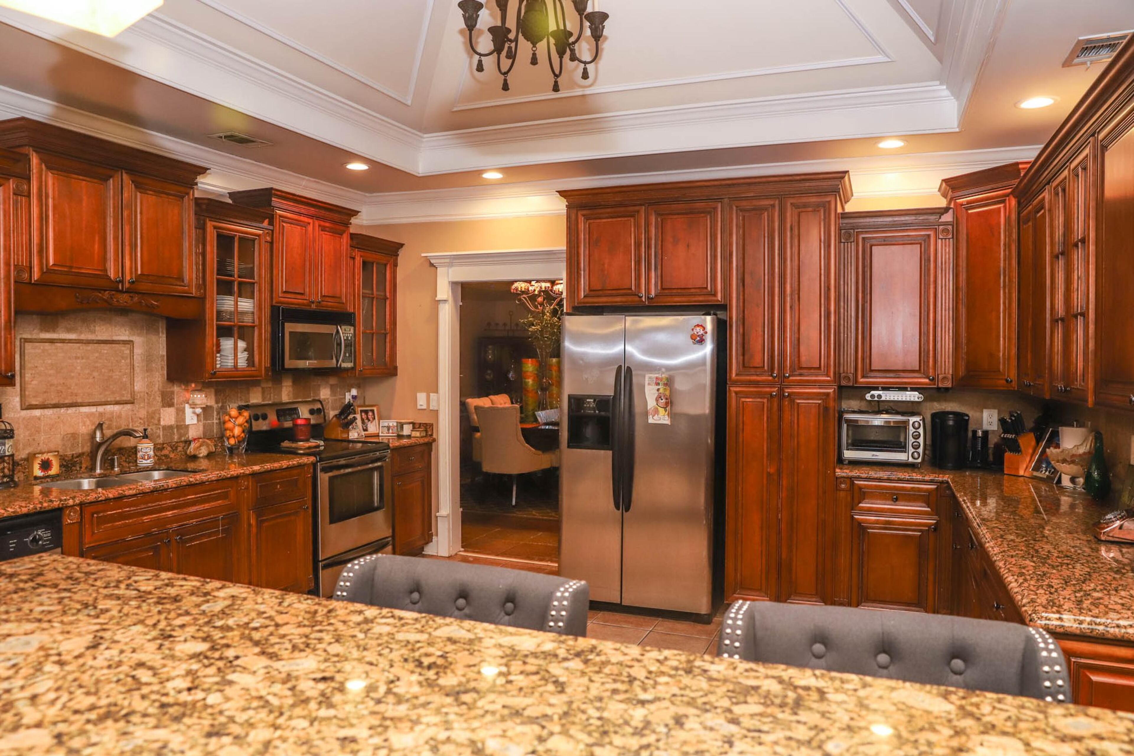 Nadine Faison’s favorite parts of her kitchen are the beautiful ceilings with wide crown molding and ample space on the granite countertops. Stools from Wayfair provide seating at the bar. Text by Shannon Dominy. Photo by Reynolds Rogers.