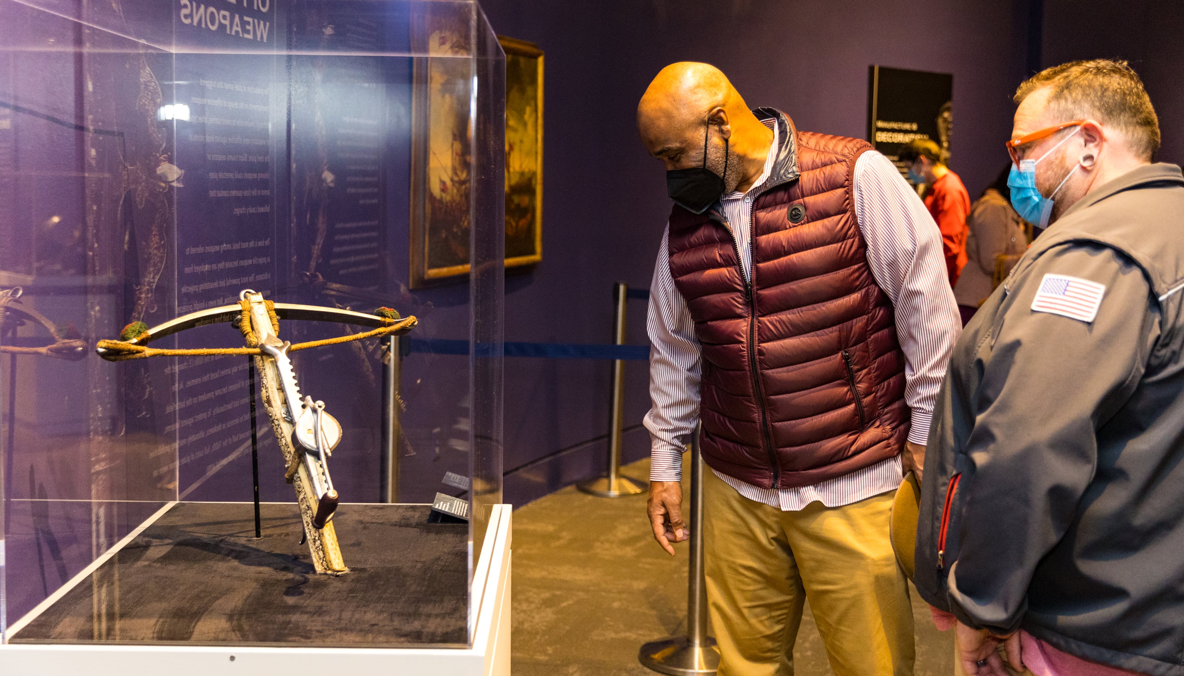 Mel Turner, from left and Tim Geter spend time looking a crossbow made of bone and carved with precision on display in the “Knights in Armor" exhibit of European armor from the 1500s on Friday, Feb 11, 2022. (Jenni Girtman for The Atlanta Journal-Constitution)