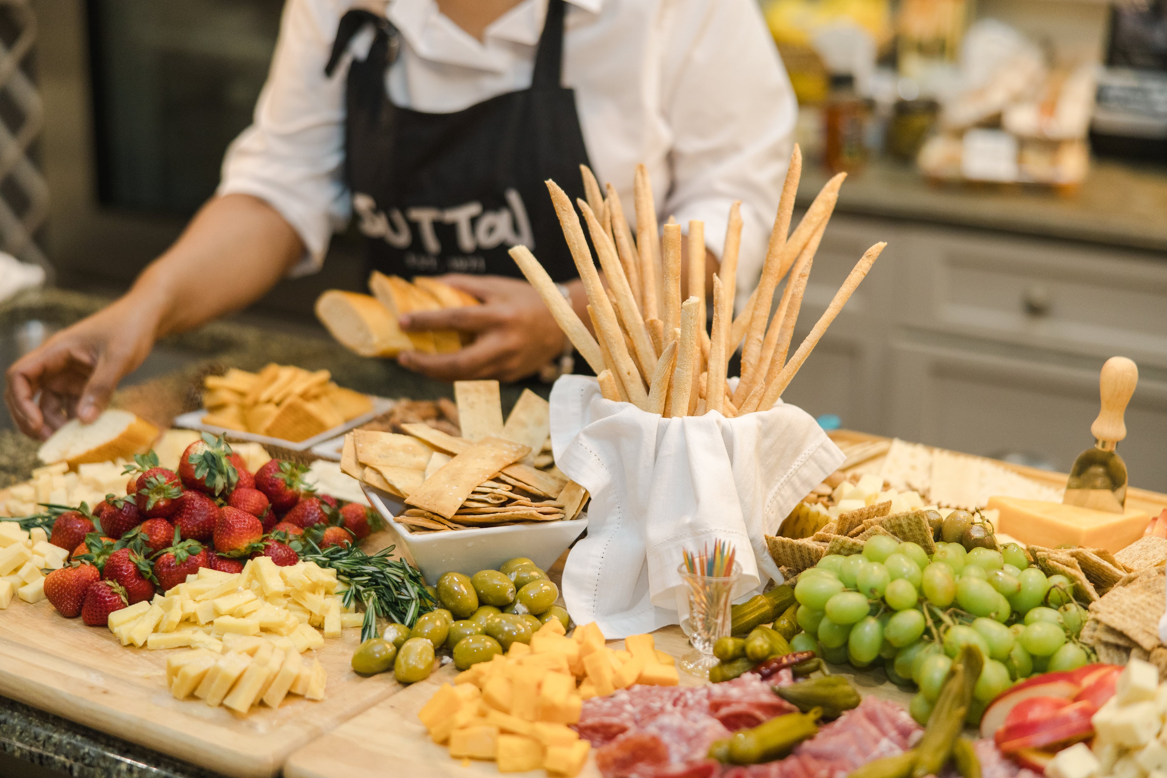 A chef presents a stunning spread at Sutton Stracke’s 2024 Masters Tournament party.