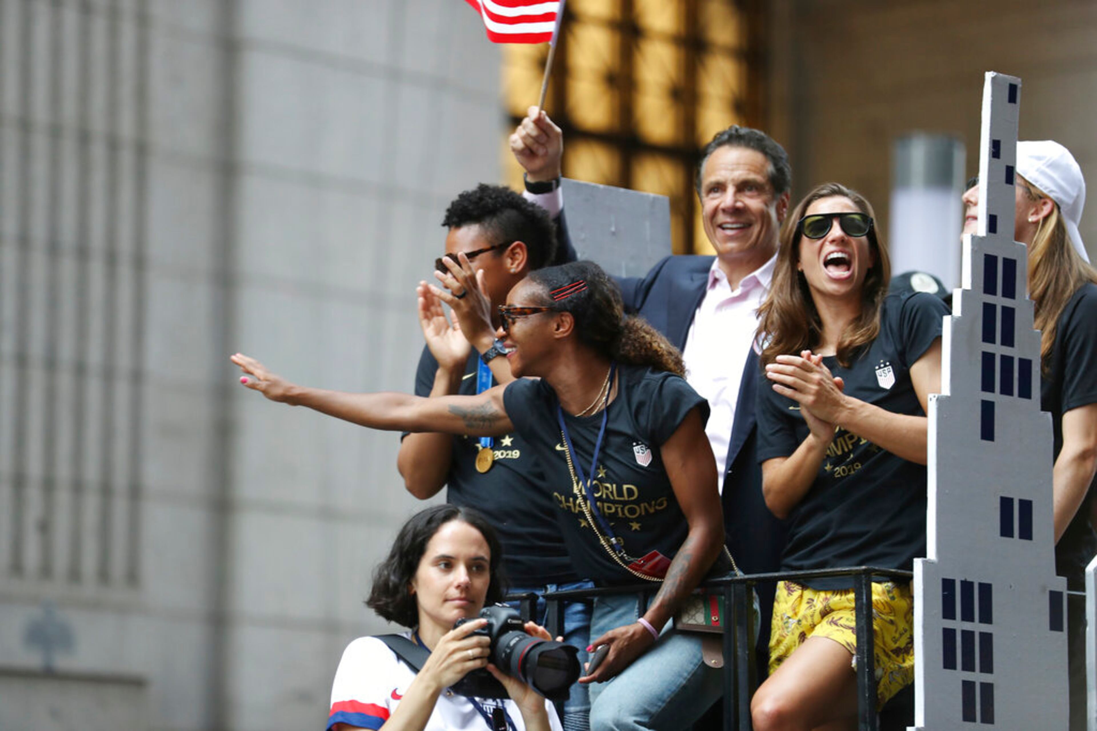 United States defender Crystal Dunn, center, and United States forward Tobin Heath, right, acknowledge the crowd on a float while being honored with a ticker tape parade along the Canyon of Heroes, Wednesday, July 10, 2019, in New York. The U.S. national team beat the Netherlands 2-0 to capture a record fourth Women's World Cup title. (AP Photo/Steve Luciano)