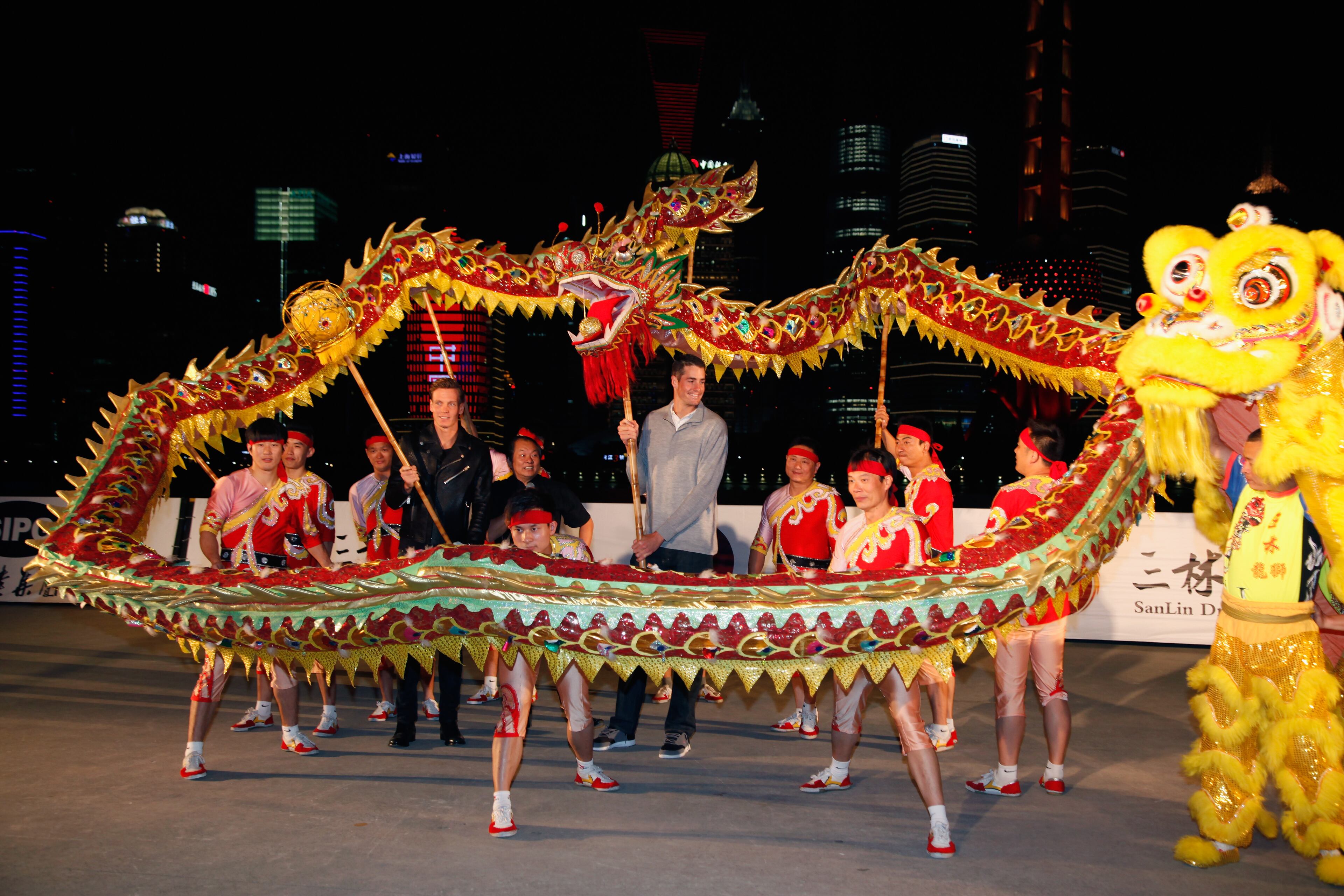 Tomas Berdych of Czech Republic and John Isner of United States, respectively No. 7 and No.15 in the Emirates ATP Race to London, poses for a picture with a Chinese dragon dance group at the Bund on October 7, 2014 in Shanghai, China. (Photo by Kevin Lee/Getty Images)