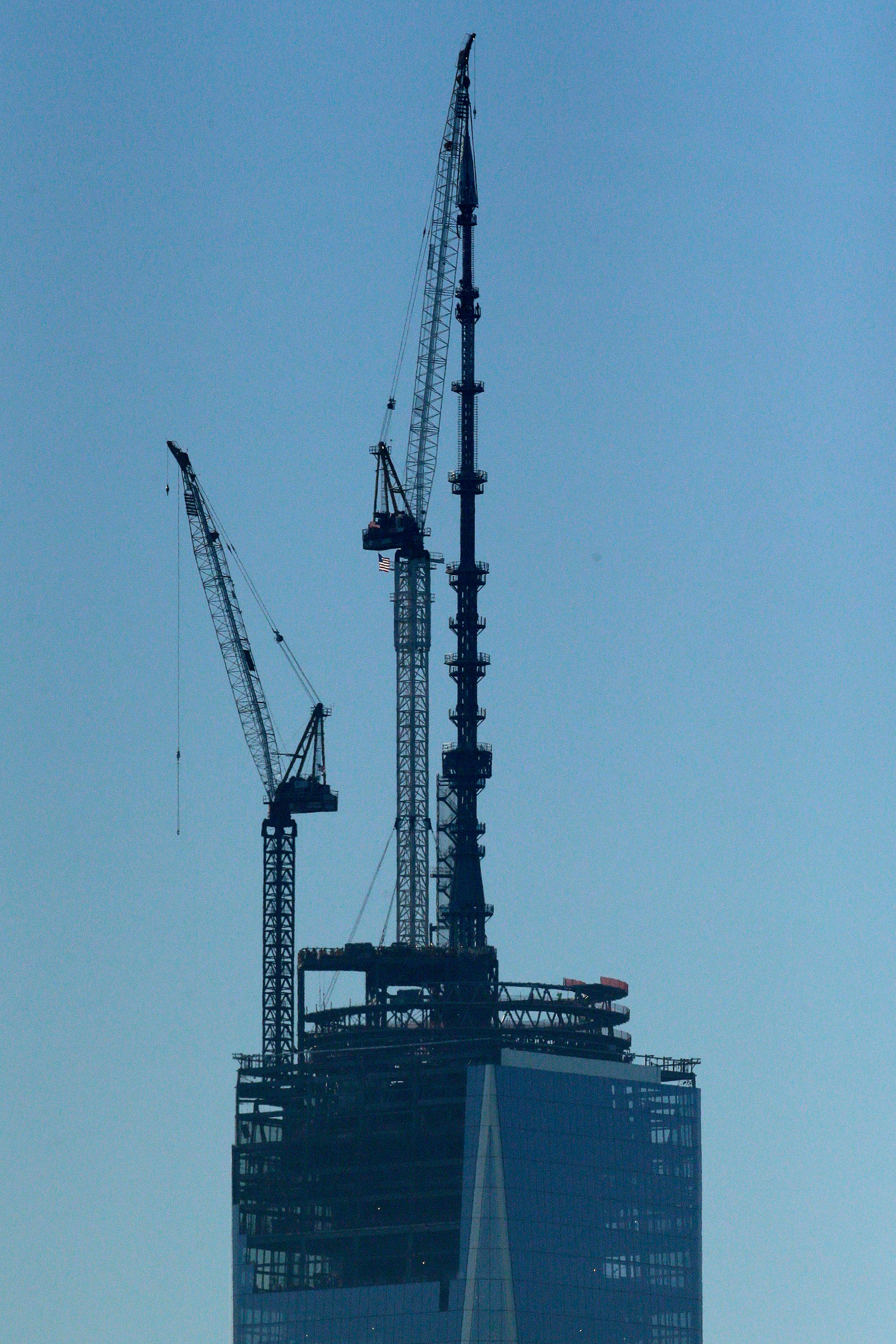 A 408-foot spire is set into place at the top of One World Trade Center seen from the Heights neighborhood of Jersey City, N.J., Friday, May 10, 2013. With the spire, the building rises at a symbolic 1,776 feet tall. (AP Photo/Julio Cortez)