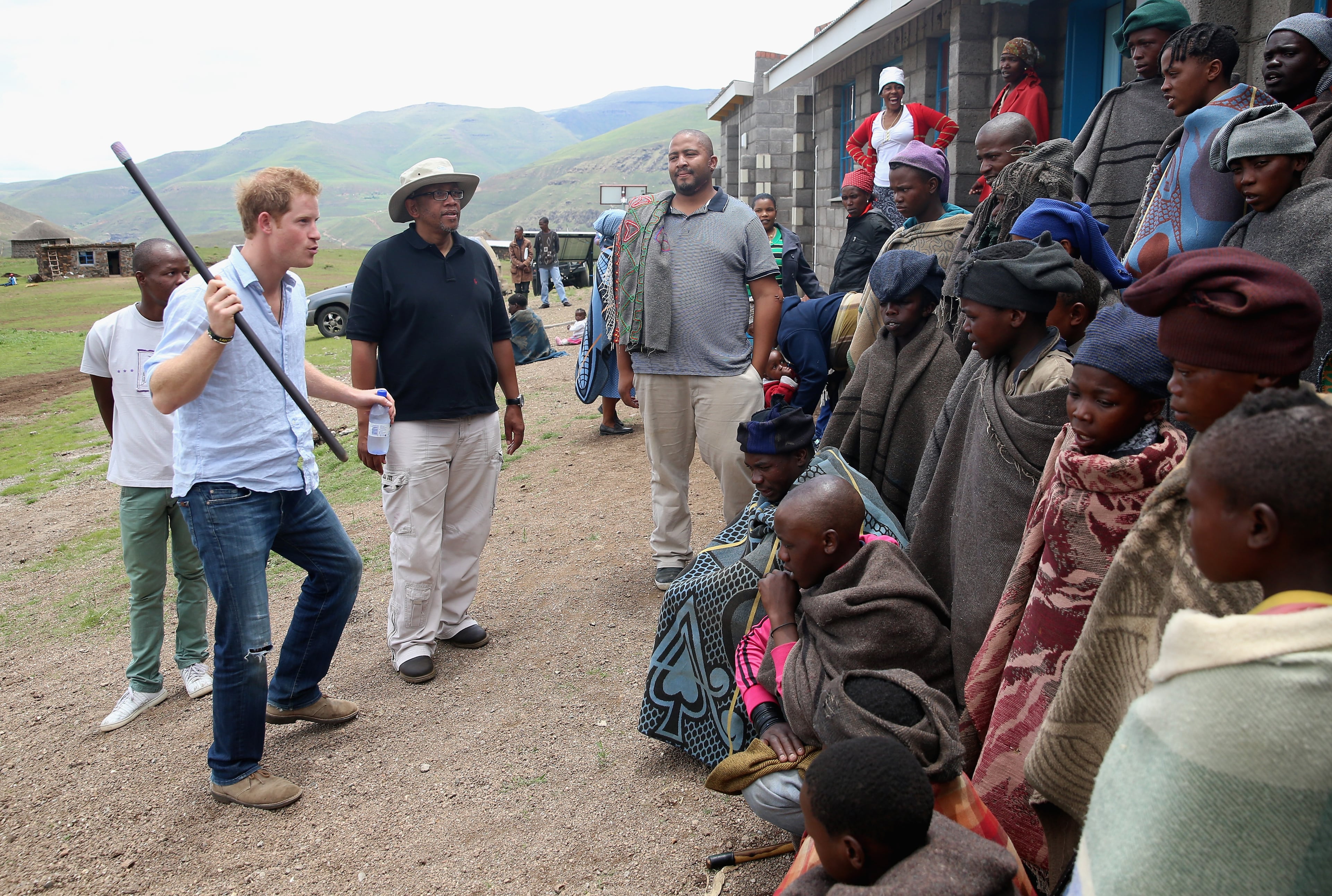 Prince Harry dances in front of herd boys with Prince Seeiso of Lesotho (in hat) during a visit to a herd boy night school constructed by Sentebale on December 8, 2014 in Maseru, Lesotho. Prince Harry was visiting Lesotho to see the work of his charity Sentebale. Sentebale provides healthcare and education to vulnerable children in Lesotho, Southern Africa. The particular theme of his visit was to check on the progress of the Mamohato Childrens Centre which will provide vital support to children affected by HIV. Prince Harry founded Sentebale (which means Forget Me Not in Sesotho) with Prince Seeiso in 2006. (Photo by Chris Jackson/Getty Images for Sentebale)