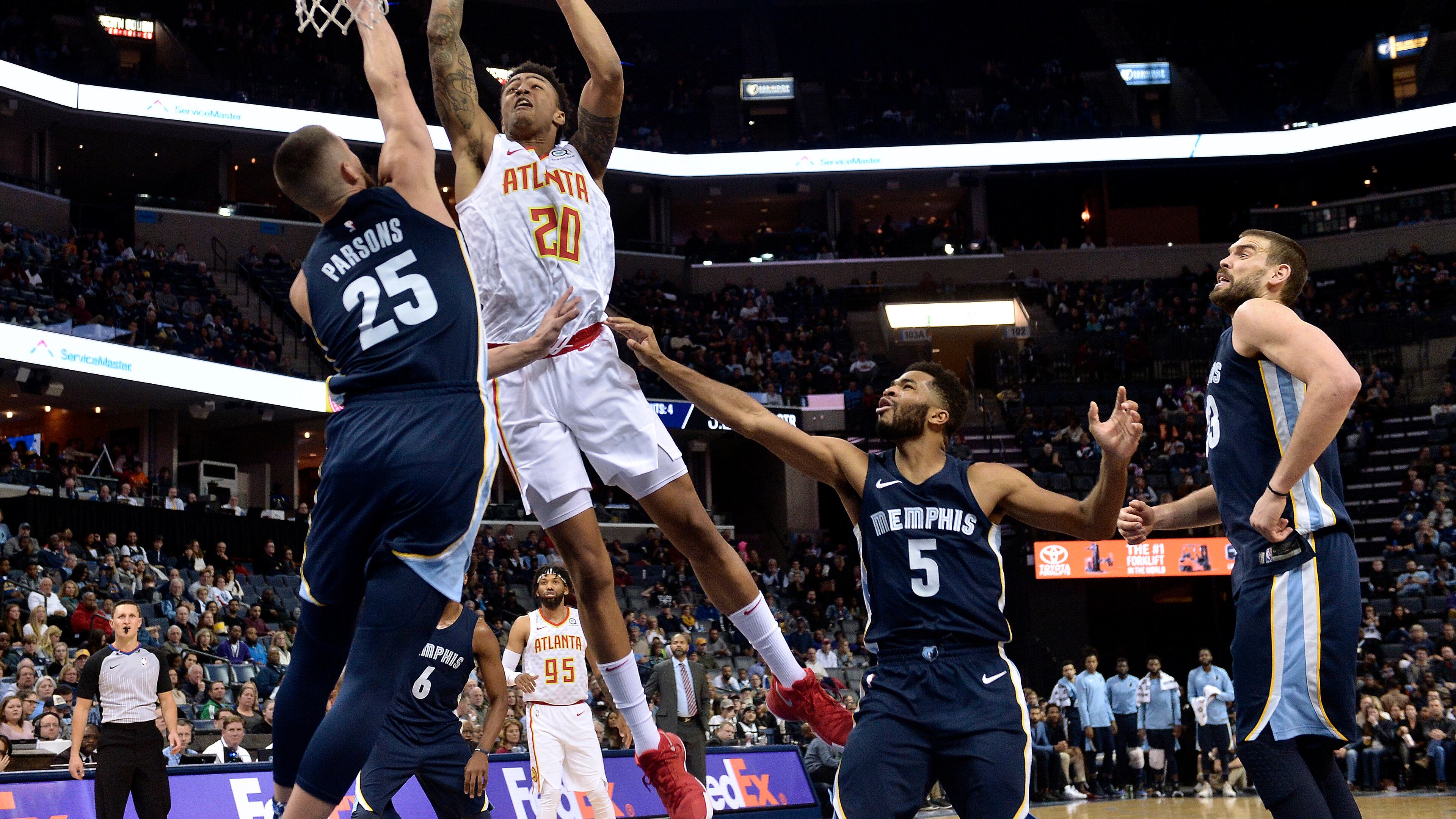 Atlanta Hawks forward John Collins (20) shoots against Memphis Grizzlies forward Chandler Parsons (25) as Grizzlies guard Andrew Harrison (5) and center Marc Gasol, right, move for position in the second half of an NBA basketball game Friday, Dec. 15, 2017, in Memphis, Tenn. (AP Photo/Brandon Dill)