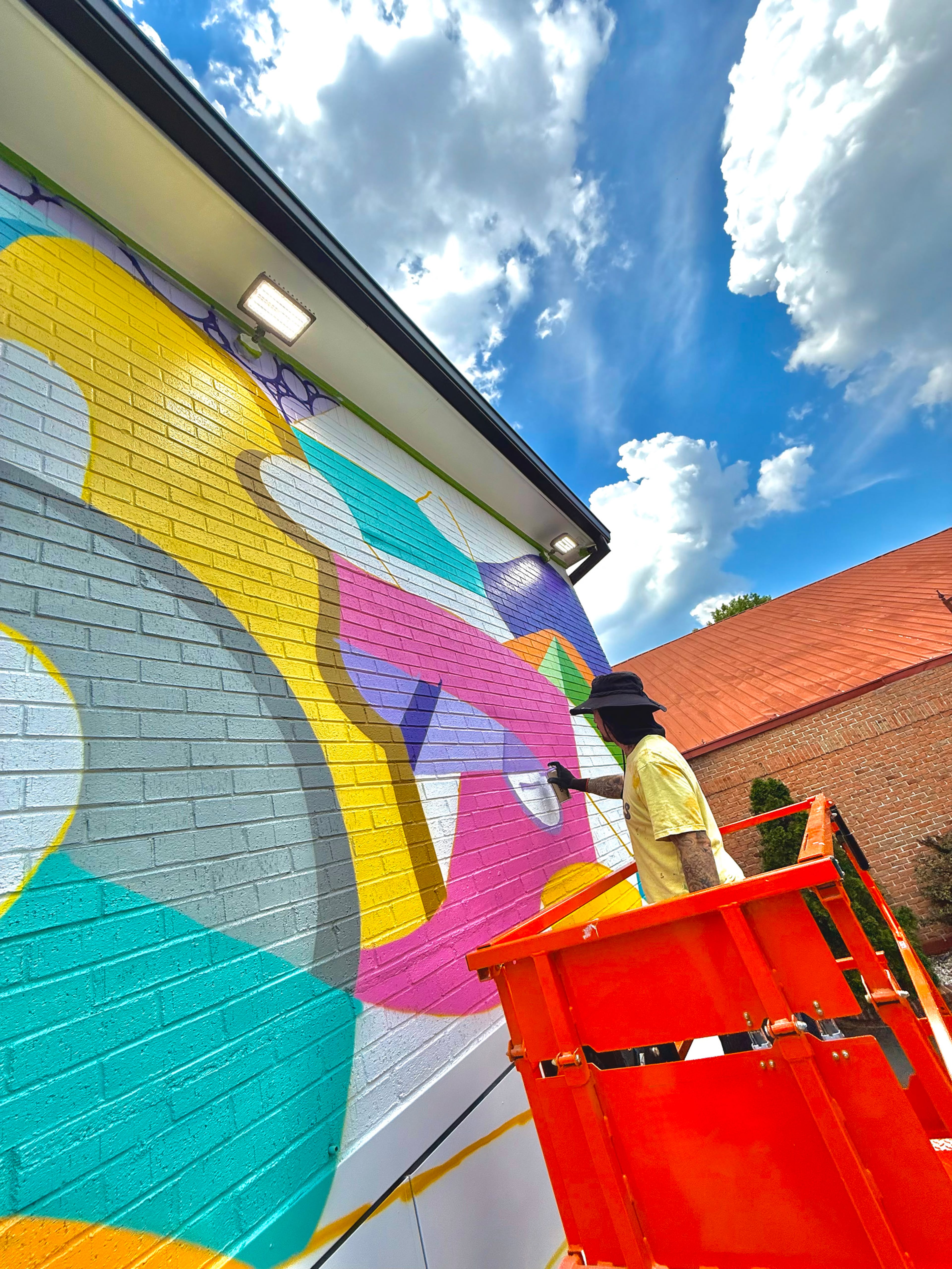 Dr. Dax completes his mural on ABV Gallery’s rear exterior wall, a composition that elaborates on the paintings hanging inside the East Atlanta space. (Courtesy of ABV Gallery)