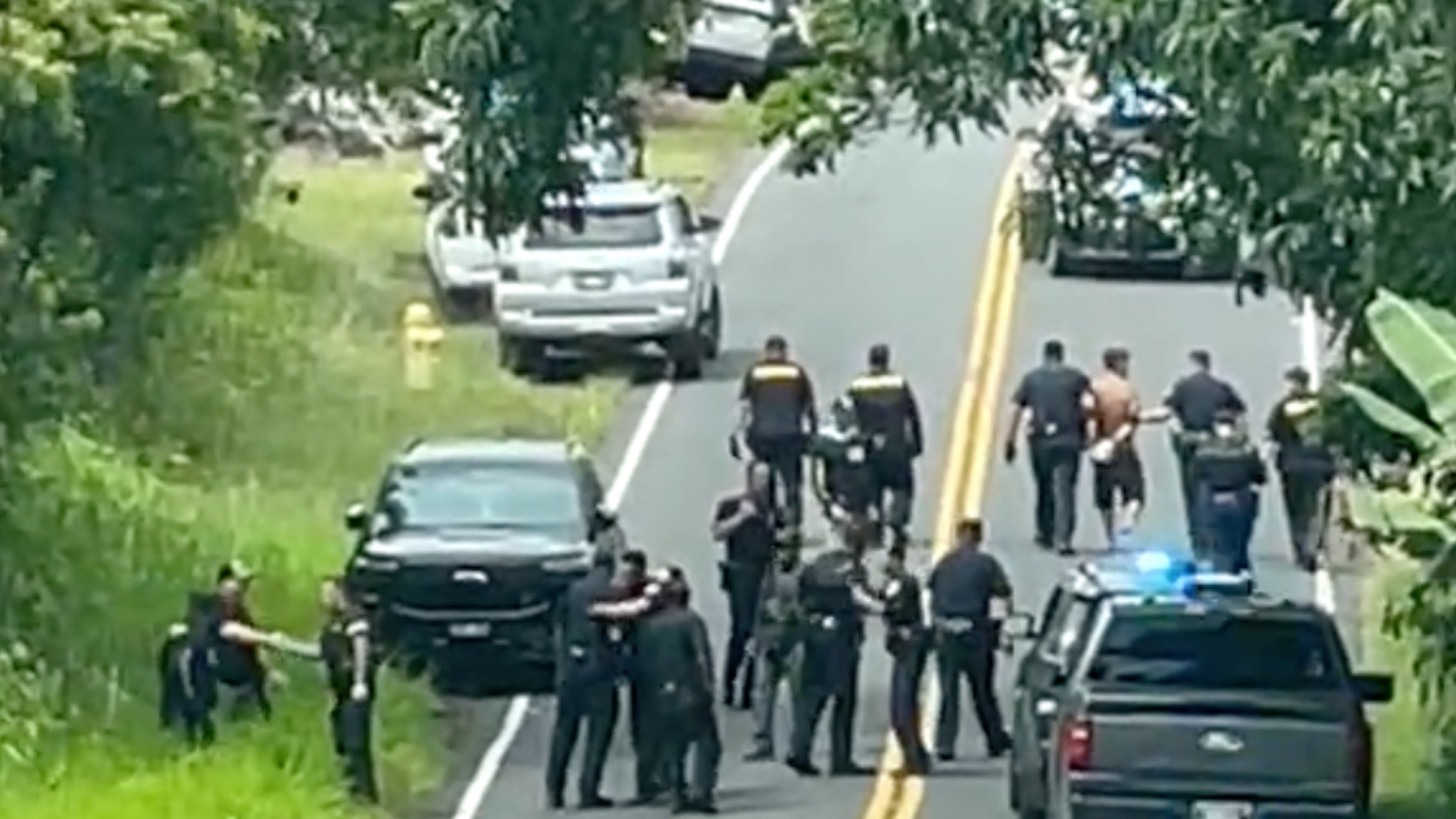 Police arrest a man accused of multiple killings, right, on Thursday, May 28, 2026, in Kaimu, Hawaii. (Deborah Davis via AP)
