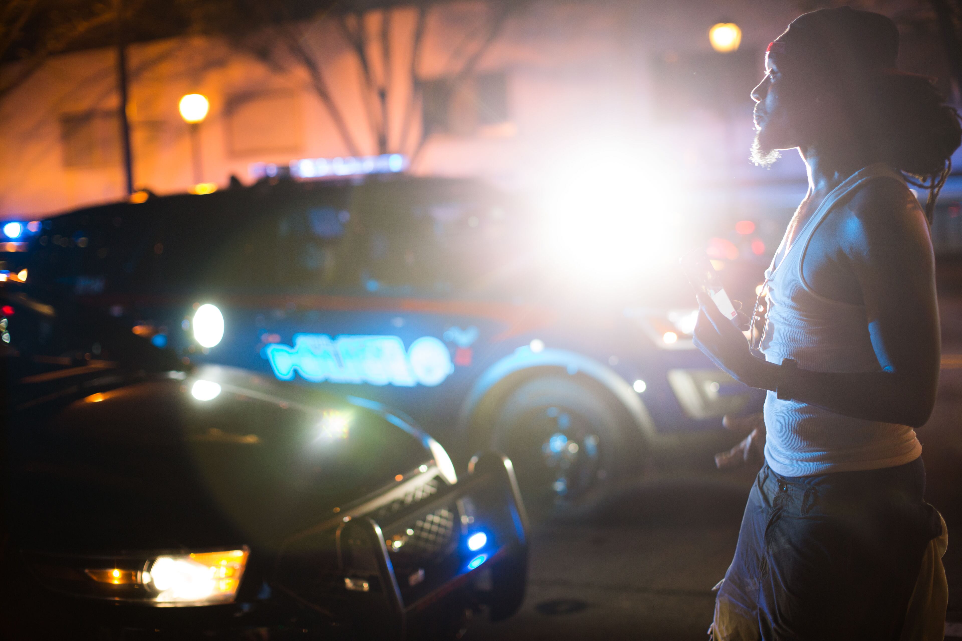 Police shine a light on a man as he walks up North Avenue, Thursday, July 7, 2016, in Atlanta, in response to the death of Alton Sterling, 37, who was killed by Baton Rouge police outside of a convenience store where he was selling CDs, and Philando Castile, who was shot and killed when Minnesota police stopped him for a traffic violation on Wednesday evening. BRANDEN CAMP/SPECIAL