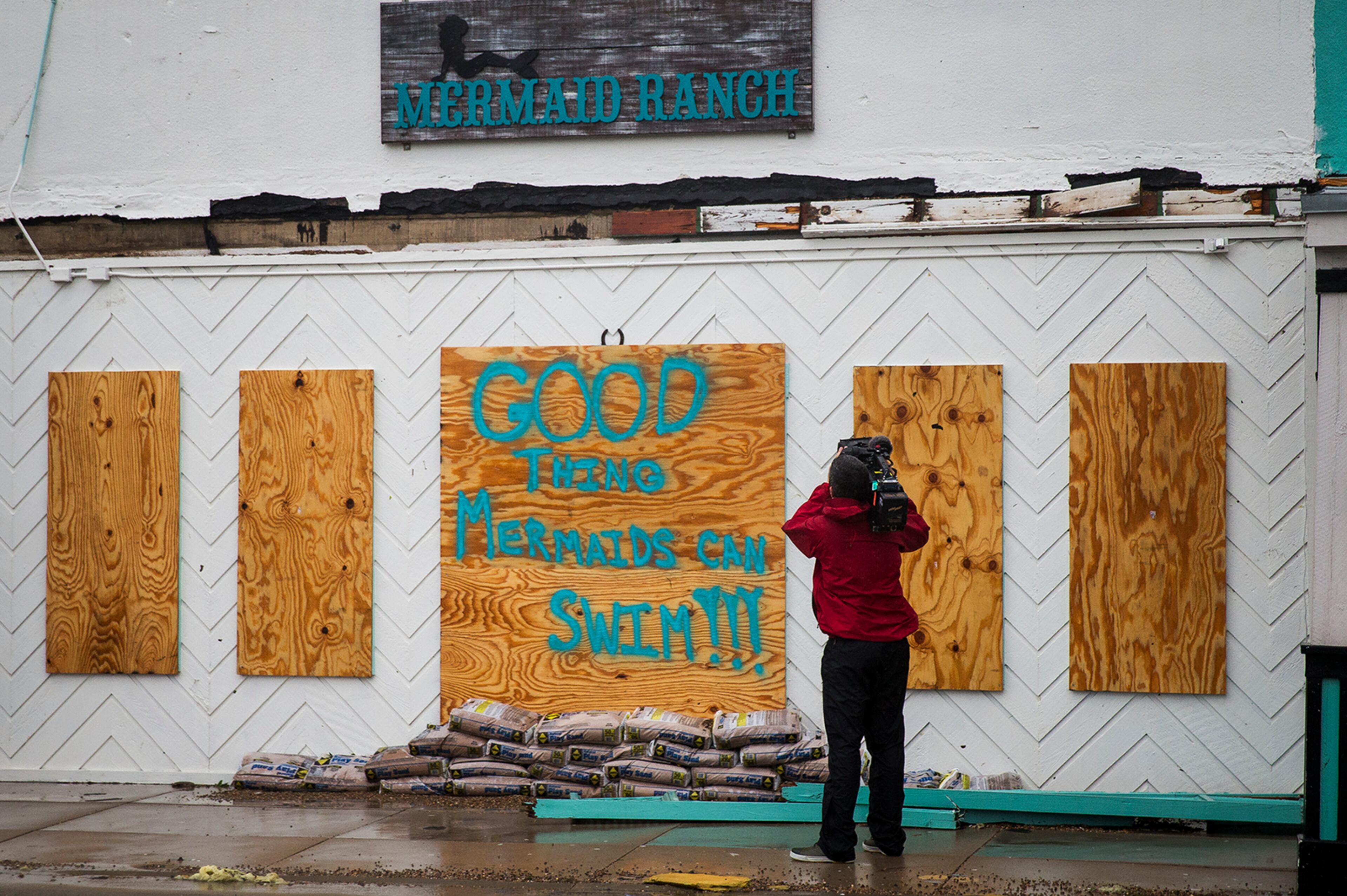 A TV cameraman films a storefront after Hurricane Harvey ripped through Rockport, Texas, on Saturday, August 26, 2017. The hurricane hit the Texas coast as a category 4 storm, damaging buildings and leaving tens of thousands without power. NICK WAGNER / AMERICAN-STATESMAN