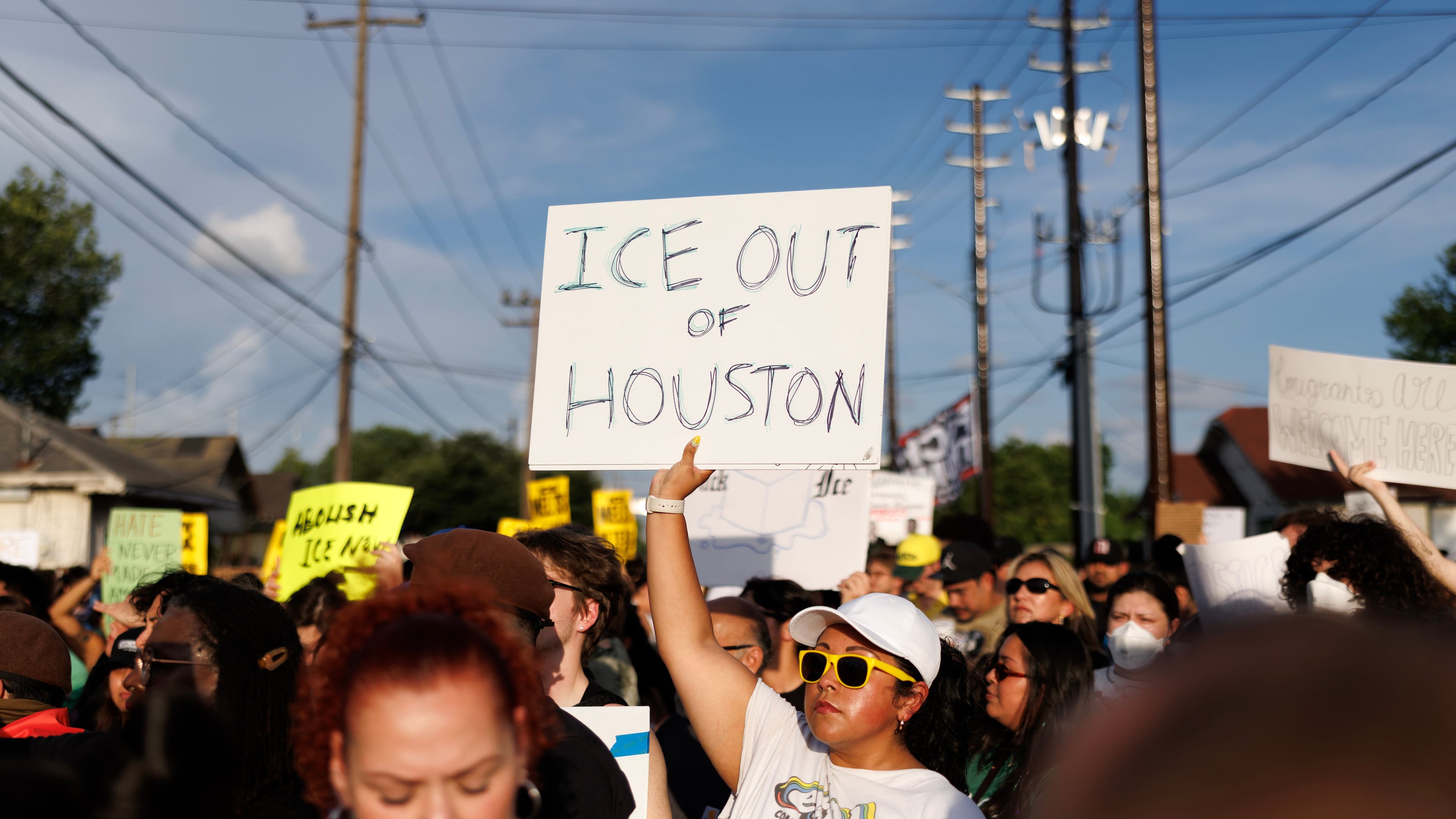 A woman holds a sign reading "ICE OUT OF HOUSTON" during a vigil for Lorenzo Salgado Araujo, a Mexican national fatally shot by a federal immigration agent a day prior, Wednesday, July 8, 2026, in Houston. (AP Photo/Mark Felix)
