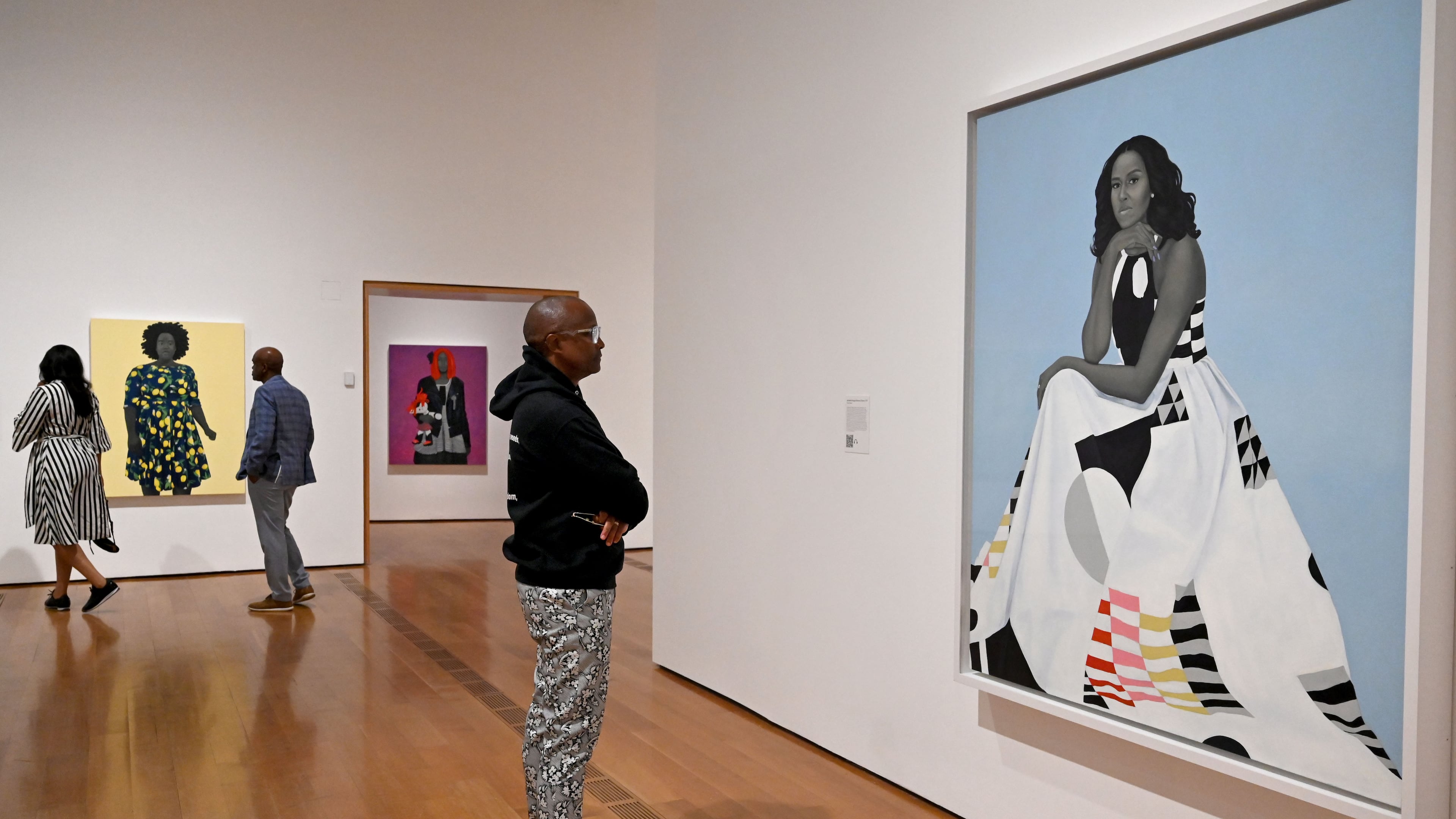A visitor looks at Amy Sherald's “Michelle Obama” in the “American Sublime” exhibition at the High Museum of Art on Friday, May 15, 2026, in Atlanta. Obama has spent years being subjected to racist and sexist attacks, guest columnist Tymia Ballard writes. (Hyosub Shin/AJC)