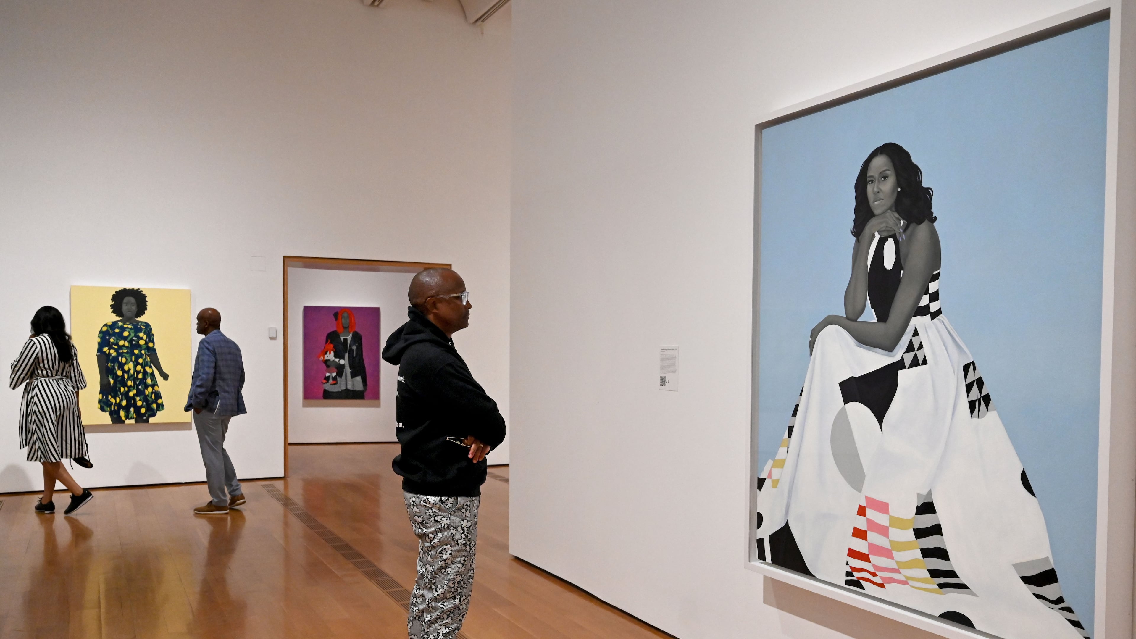 A visitor looks at Amy Sherald's “Michelle Obama” in the “American Sublime” exhibition at the High Museum of Art on Friday, May 15, 2026, in Atlanta. Obama has spent years being subjected to racist and sexist attacks, guest columnist Tymia Ballard writes. (Hyosub Shin/AJC)