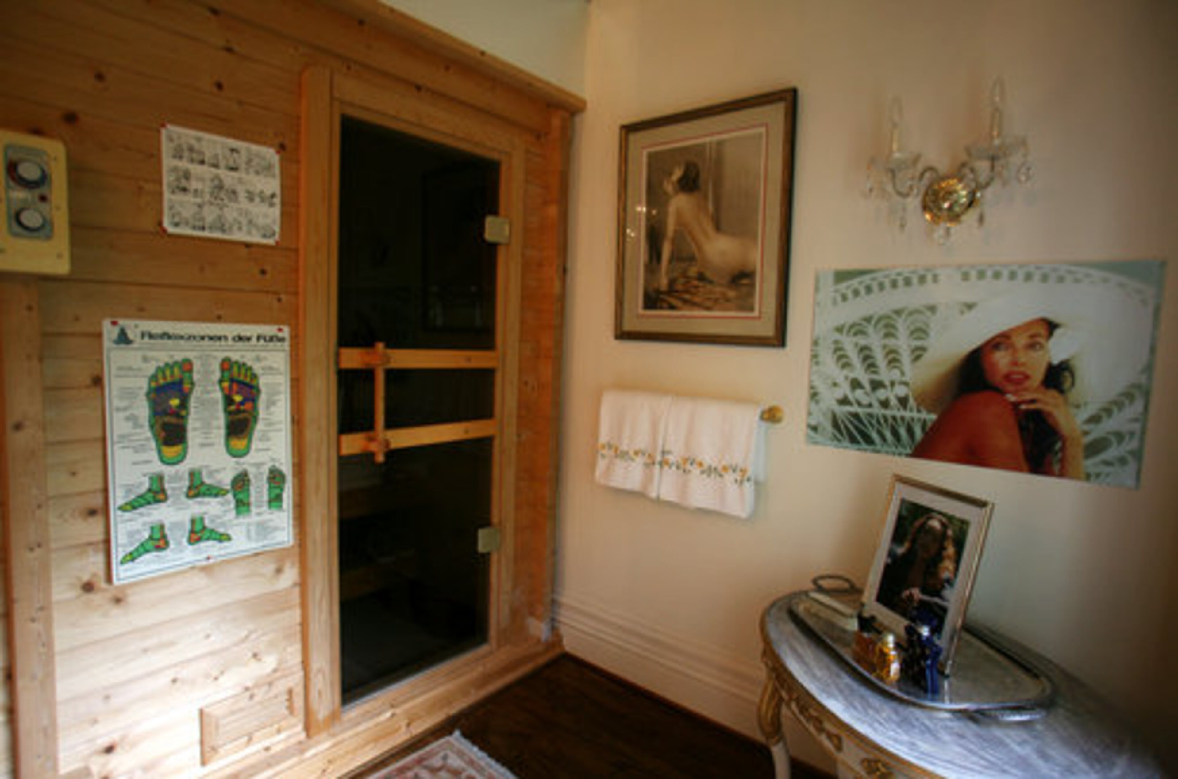The master bath also includes this sauna, which Alexandra had imported from Finland. At the right is a photo of Alexandra wearing a white hat from her modeling portfolio.