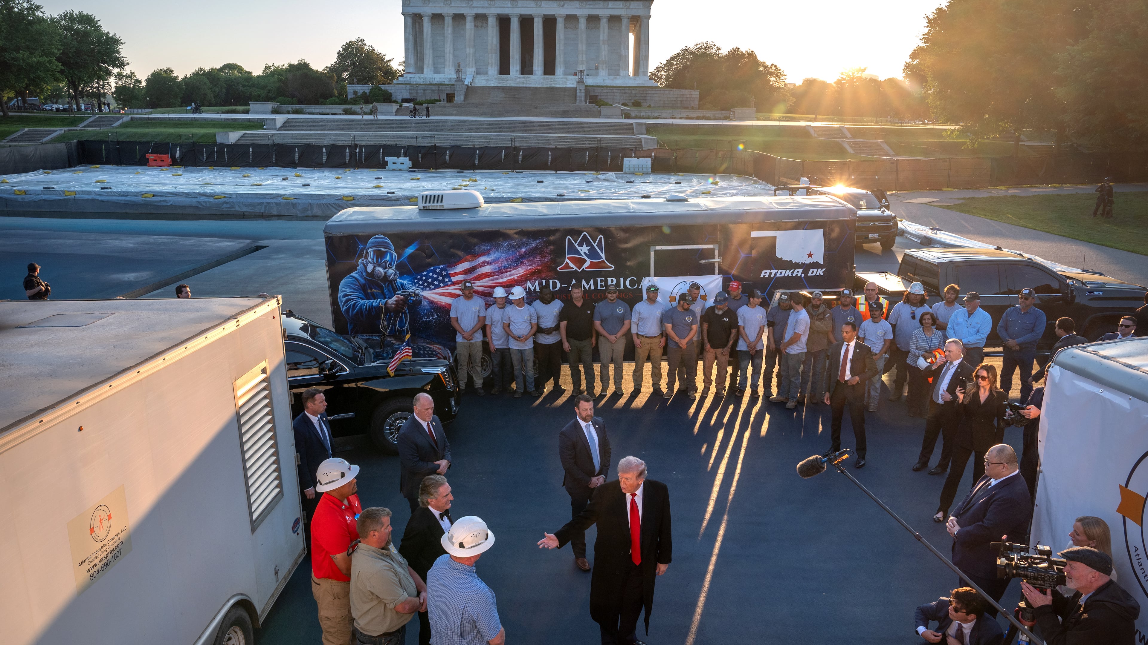 President Donald Trump talks as he visits the Lincoln Memorial Reflecting Pool to see the new blue protective coating being applied as part of a renovation project, Thursday, May 7, 2026, in Washington. (AP Photo/Mark Schiefelbein)