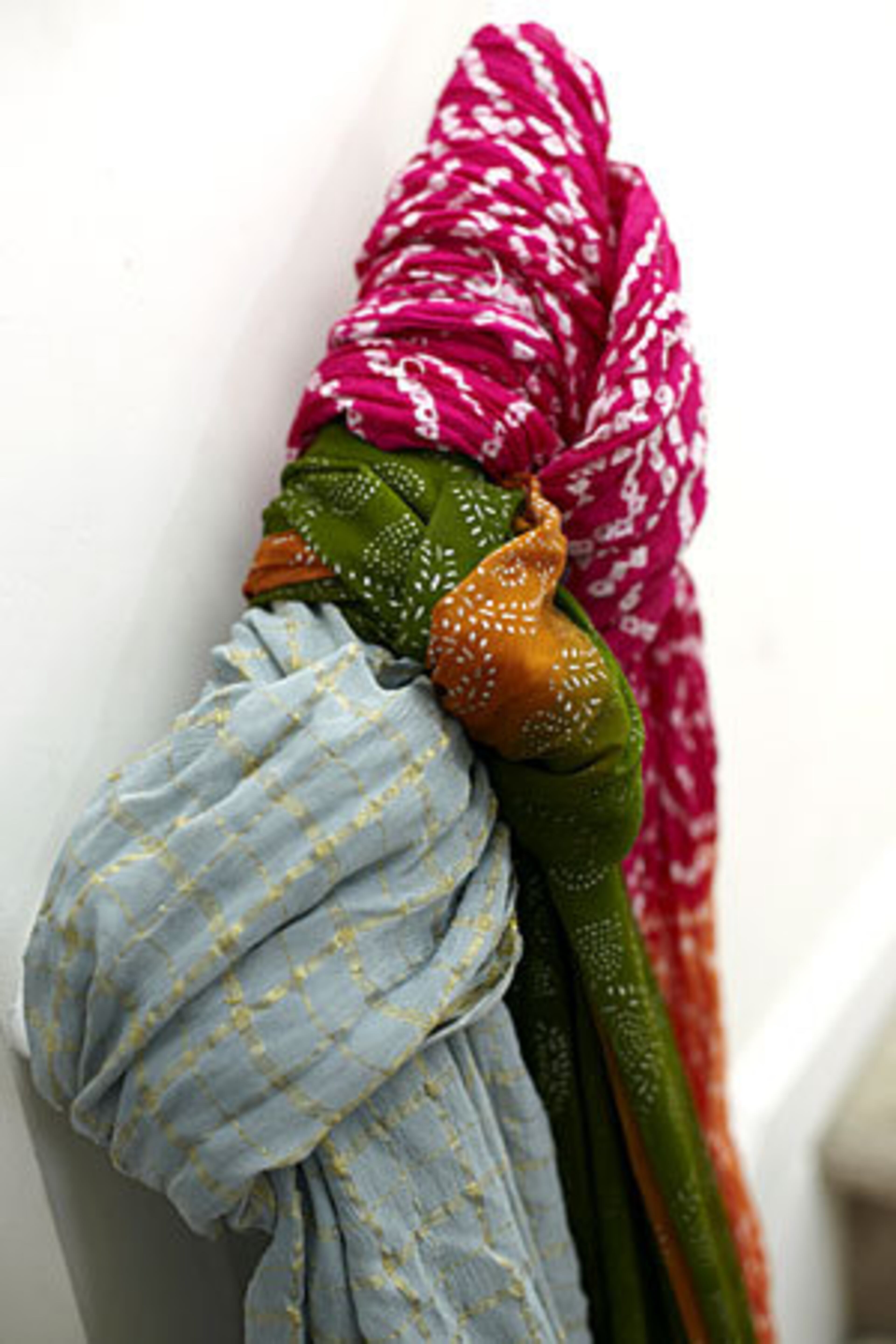 Raushanah El-Amin-Foster has a large collection of scarves including a gray scarf with beaded accents and a green and copper scarf with silver accents, both from Sanriq Styles. El-Amin-Foster also owns a fuschia and orange tie-dye scarf from Target.