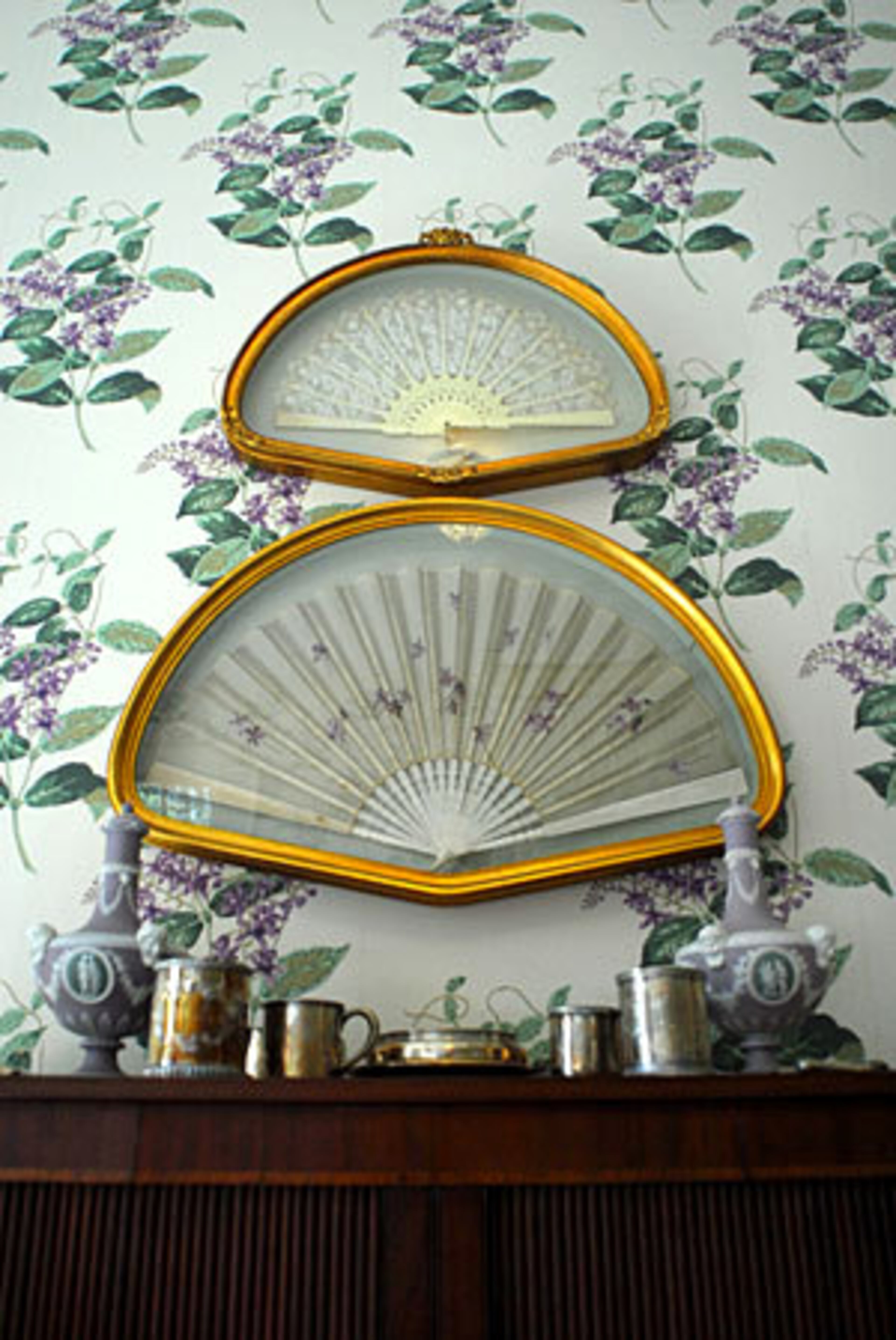 Anne Colgin's grandmother, Florida Wellborn Morgan, carried the larger fan during her wedding in 1903. (The fan above it was purchased.) On the table are Wedgewood barber bottles from 1867.