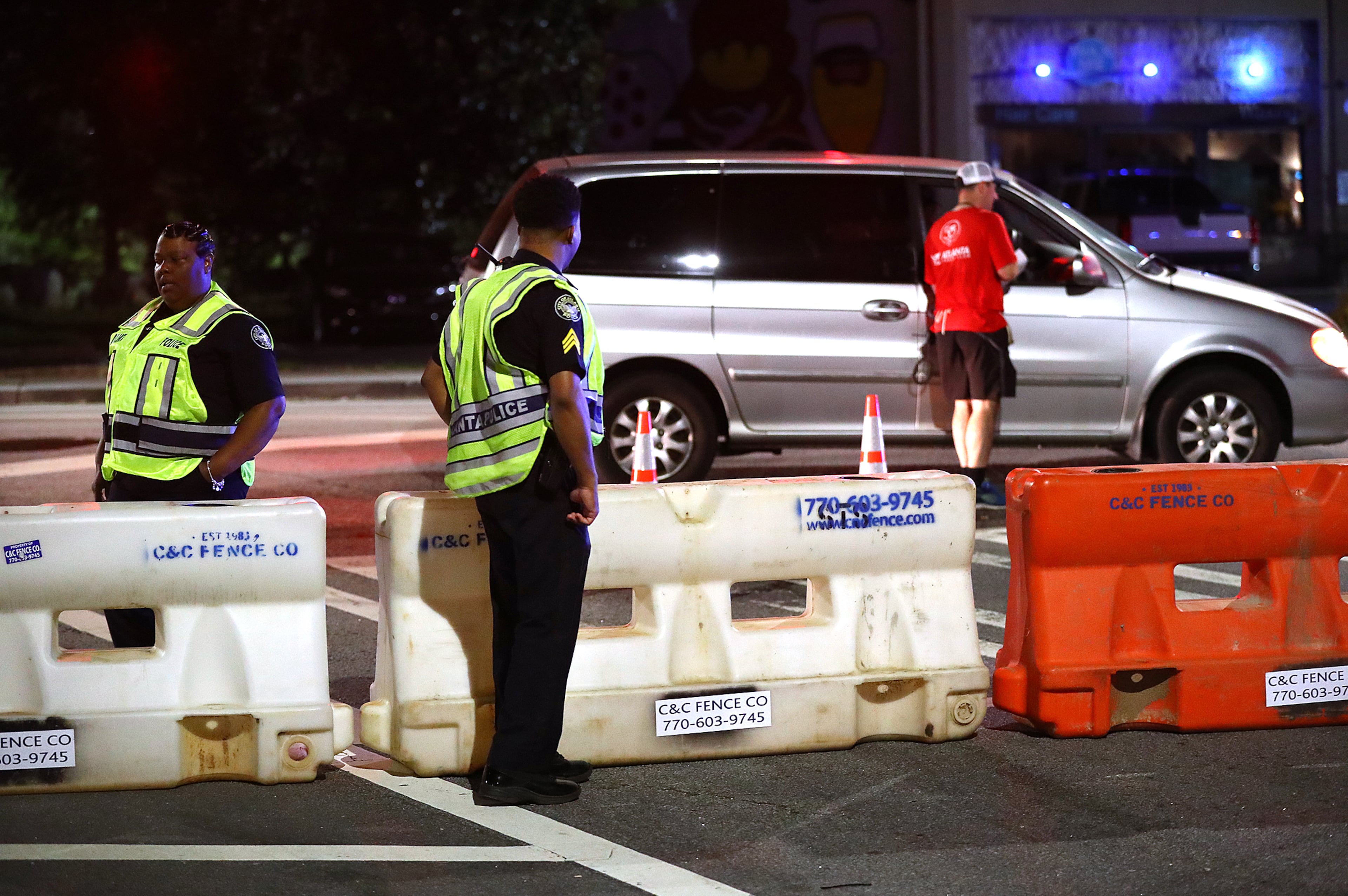 Atlanta police officers man a barricade at 10th Street and Monroe Drive NE as roads are shut down for the 2019 Peachtree Road Race. (AJC FILE)