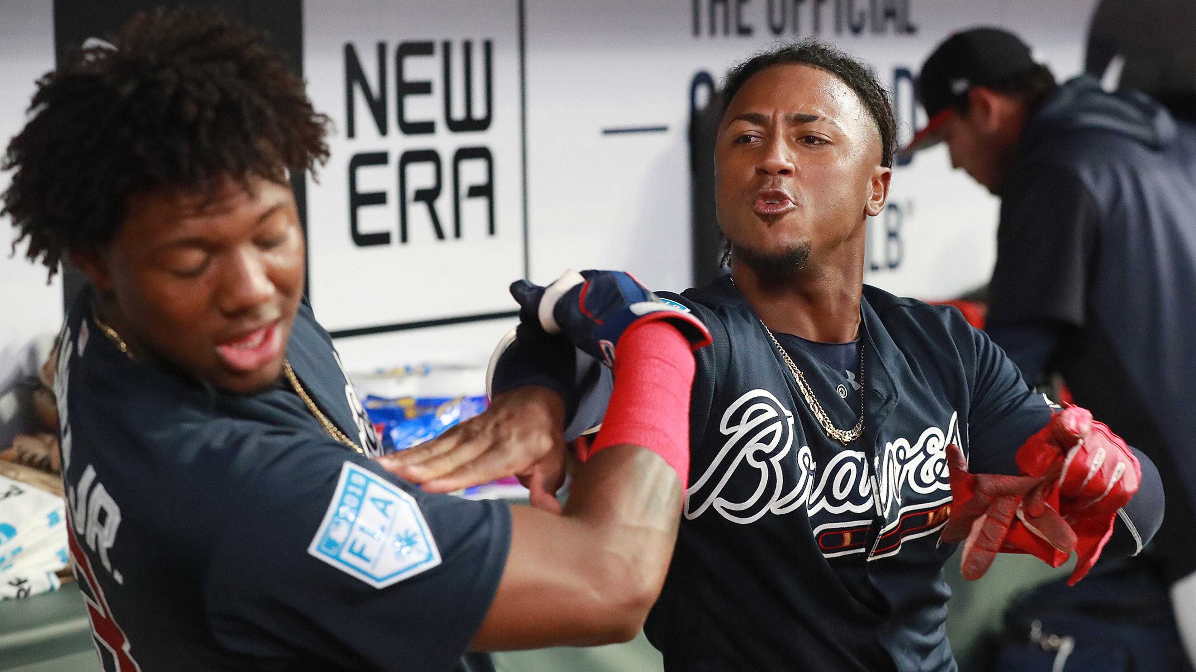 Braves infielder Ozzie Albies gives teammate Ronald Acuna a shove in the dugout clowning around after scoring against the Cincinnati Reds during the second inning Monday, March 25, 2019, at SunTrust Park in Atlanta.