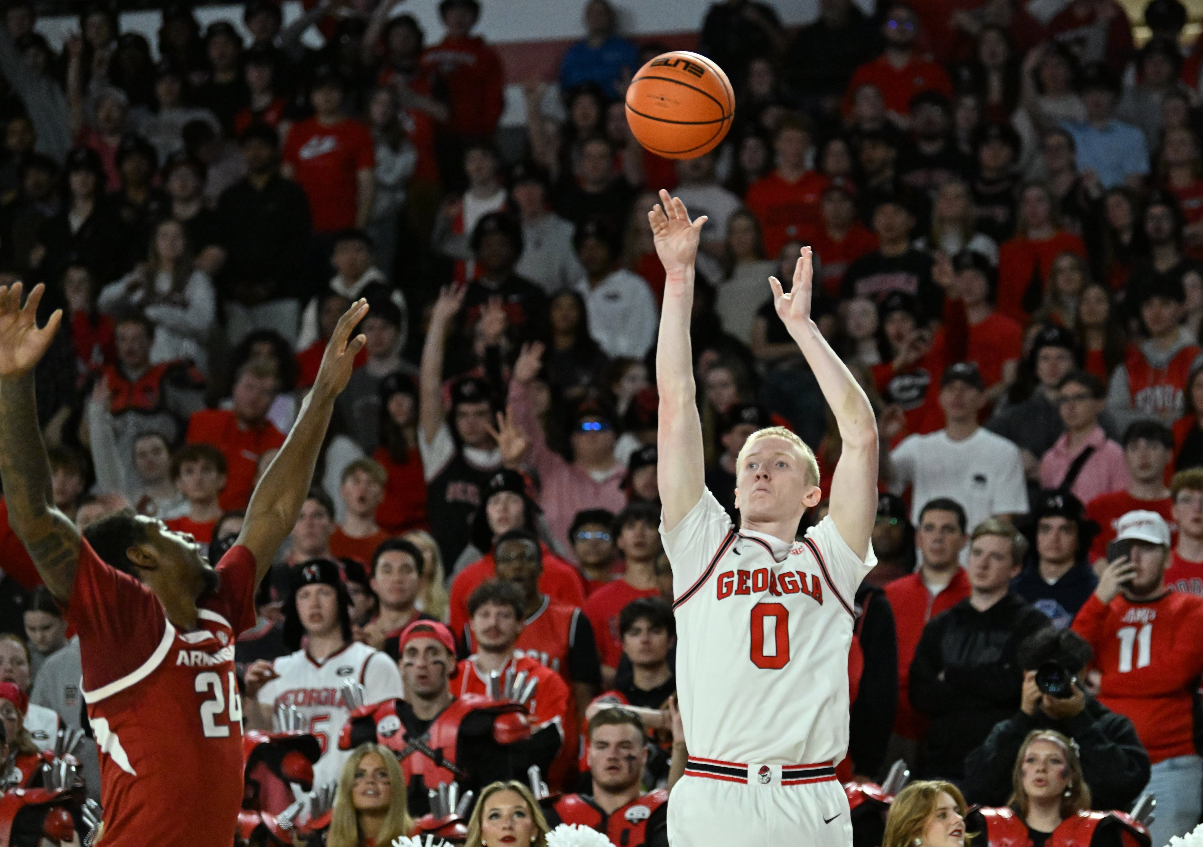 Georgia guard Blue Cain gets off a shot against Arkansas forward Billy Richmond III during the first half in an NCAA college basketball game at Stegeman Coliseum, Saturday, Jan. 17, 2026, in Athens. (Hyosub Shin/AJC)