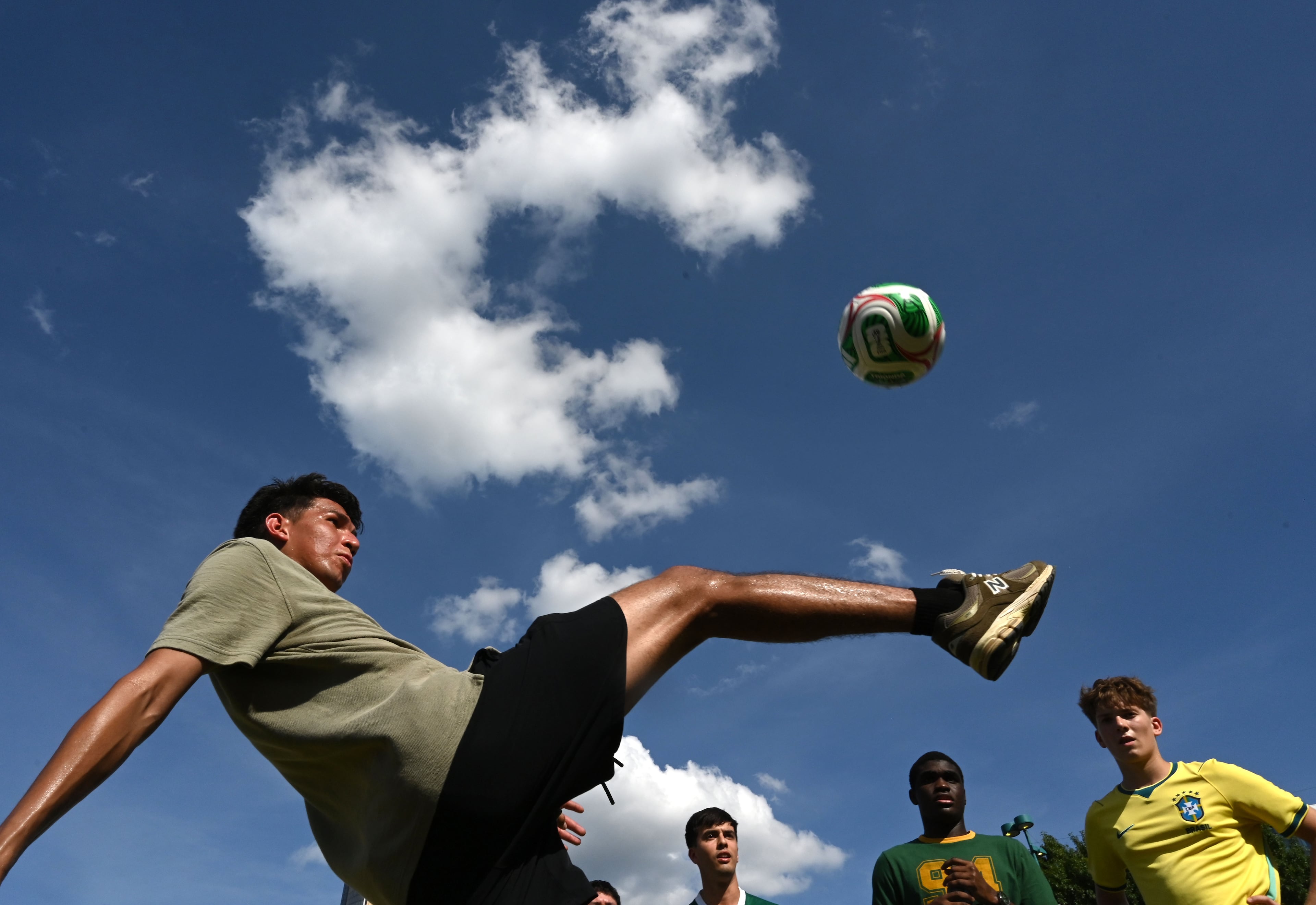 Soccer fans play with a soccer ball while gathering for a watch party ahead of the match between Brazil and Morocco at the FIFA Fan Festival in Centennial Olympic Park on Saturday, June 13, 2026, in Atlanta. (Hyosub Shin/AJC)