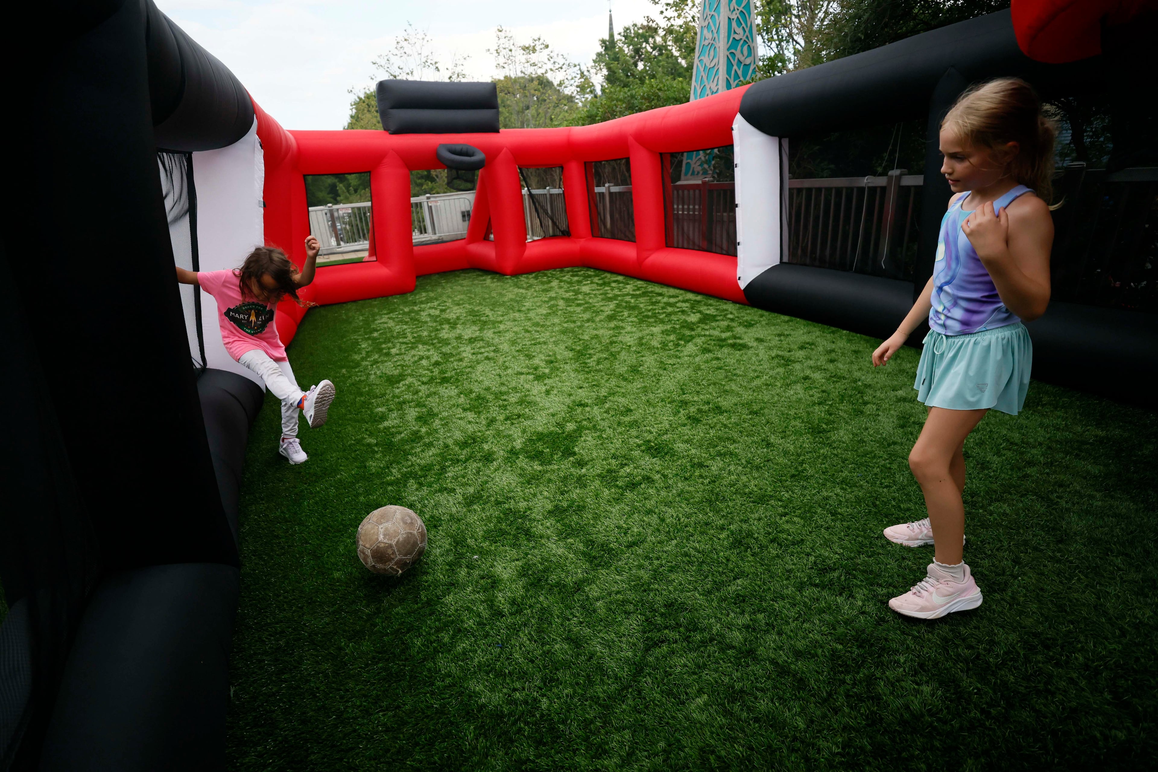 Darby Jones (right) and her sister, Cecily Jones, of Candler Park play soccer at the kids’ playground at Decatur Square during Decatur WatchFest ’26 on Thursday, June 25, 2026. (Miguel Martinez/AJC)