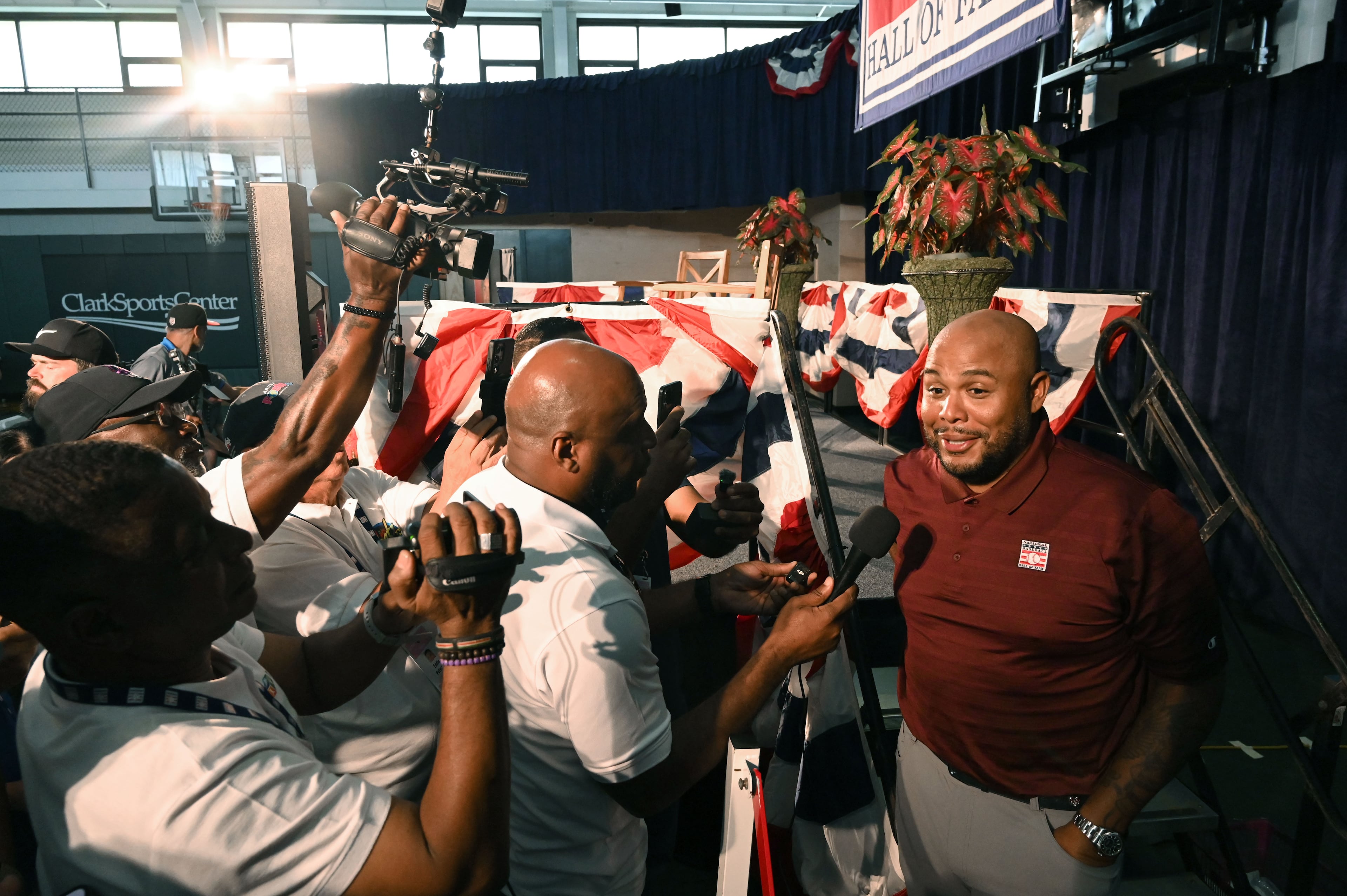 Former Brave Andruw Jones (right) is surrounded by members of the media at the Clark Sports Center on Saturday, July 25, 2026, in Cooperstown, N.Y. Jones will be inducted into the National Baseball Hall of Fame on Sunday as part of the Class of 2026. The beloved Braves center fielder was known for his defensive acumen and power. (Hyosub Shin/AJC)
