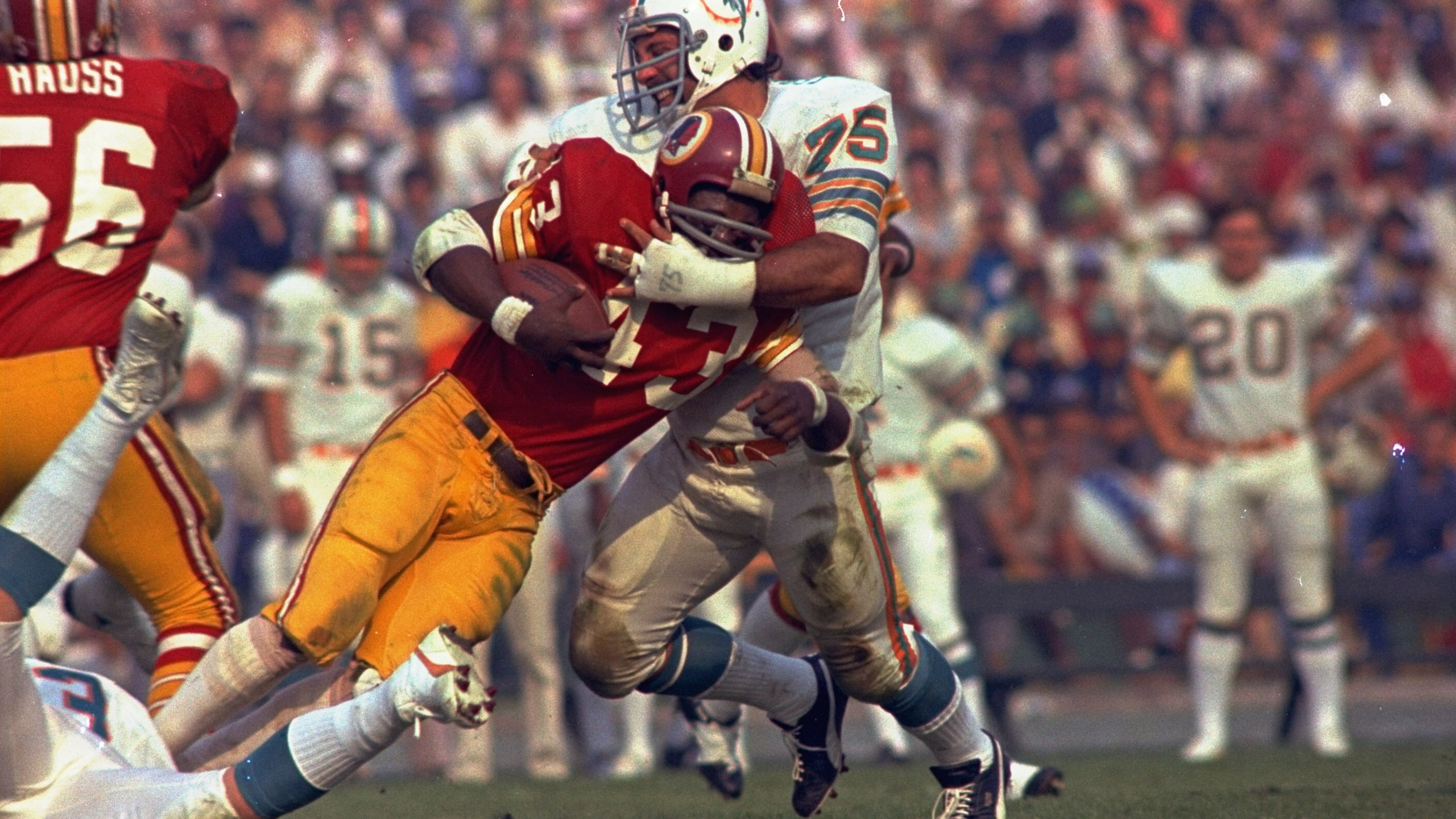 Washington Redskins running back Larry Brown (43) is stopped in his tracks by Miami Dolphins defender Manny Fernandez (75) during the NFL football Super Bowl VII game in Los Angeles, Jan. 14, 1973. (AP Photo/File)