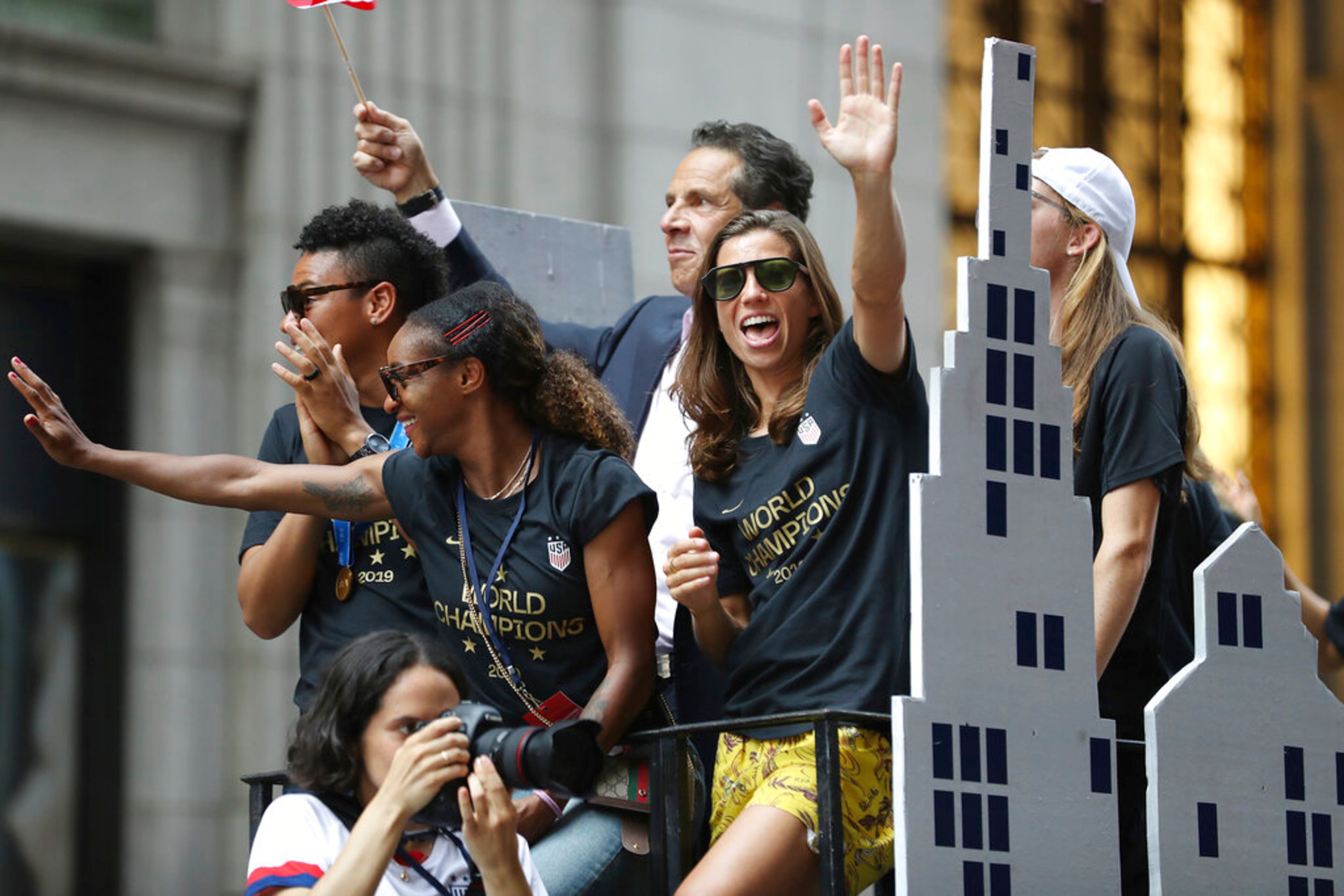 United States defender Crystal Dunn, center, and United States forward Tobin Heath, right, wave to the crowd on a float while being honored with a ticker tape parade along the Canyon of Heroes, Wednesday, July 10, 2019, in New York. The U.S. national team beat the Netherlands 2-0 to capture a record fourth Women's World Cup title. (AP Photo/Steve Luciano)