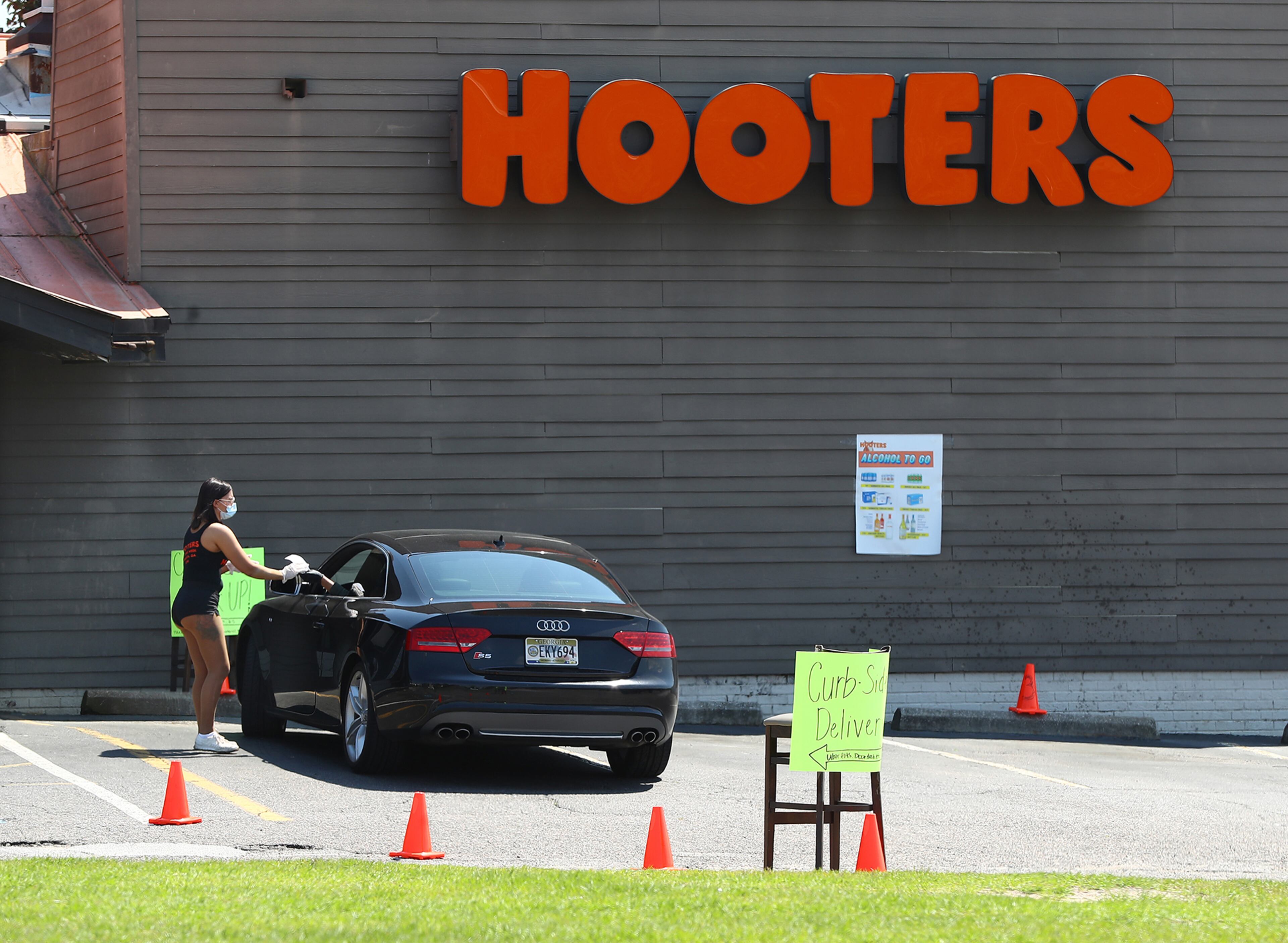 April 6, 2020 Augusta: A Hooters girl wearing a mask waits on the one car in the parking lot for carry out food on what would have been the first practice round for the Masters bringing large crowds of patrons to town on Monday, April 6, 2020, in Augusta. In collaboration with the leading organizations in golf, Augusta National Golf Club has identified November 9-15 as the intended dates to host the 2020 Masters. Curtis Compton ccompton@ajc.com
