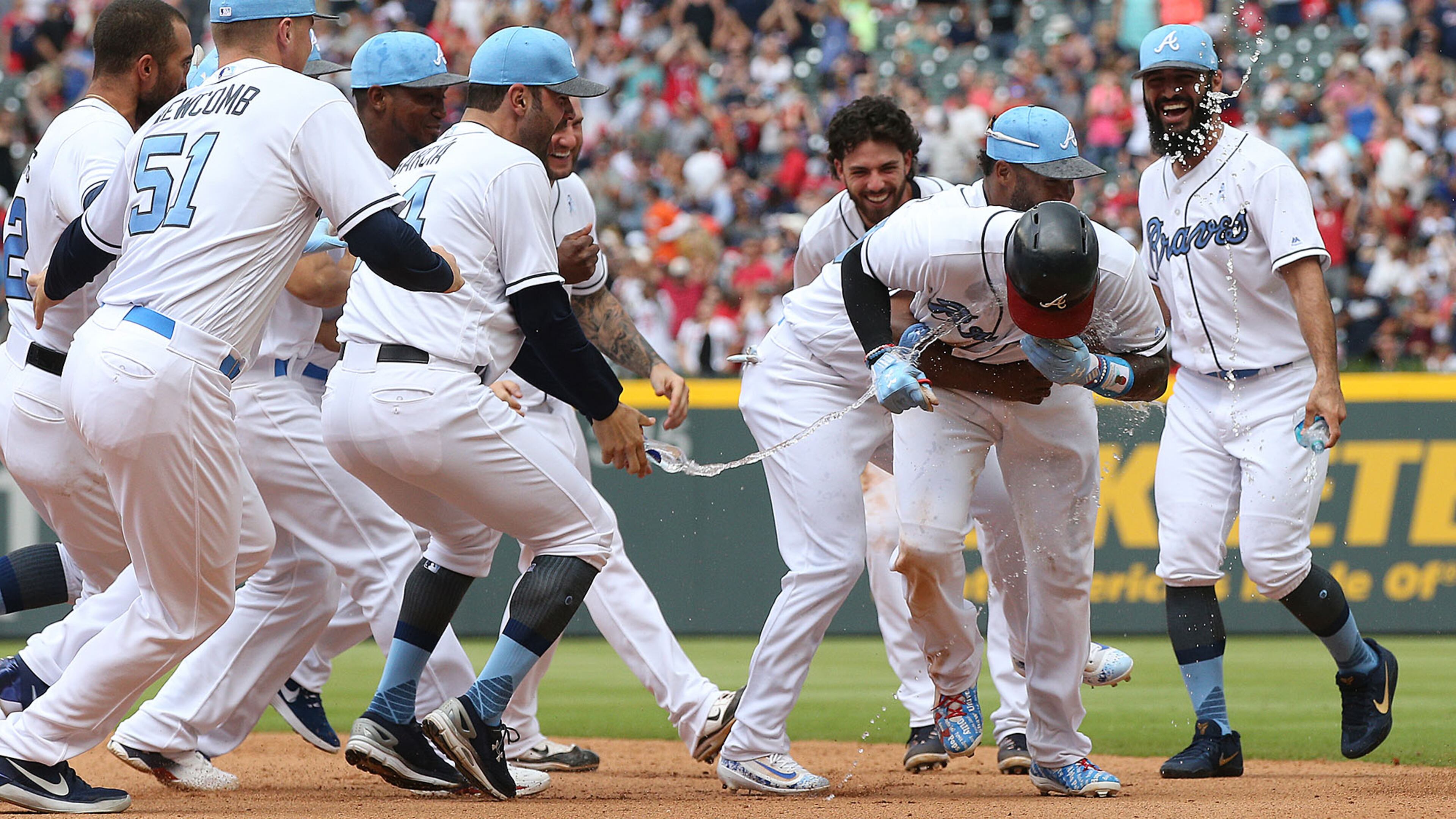 Teammates mob Atlanta Braves Brandon Phillips after he hit a walk-off RBI single to beat the Miami Marlins 5-4 during the 9th inning Sunday, June 18, 2017, in Atlanta.