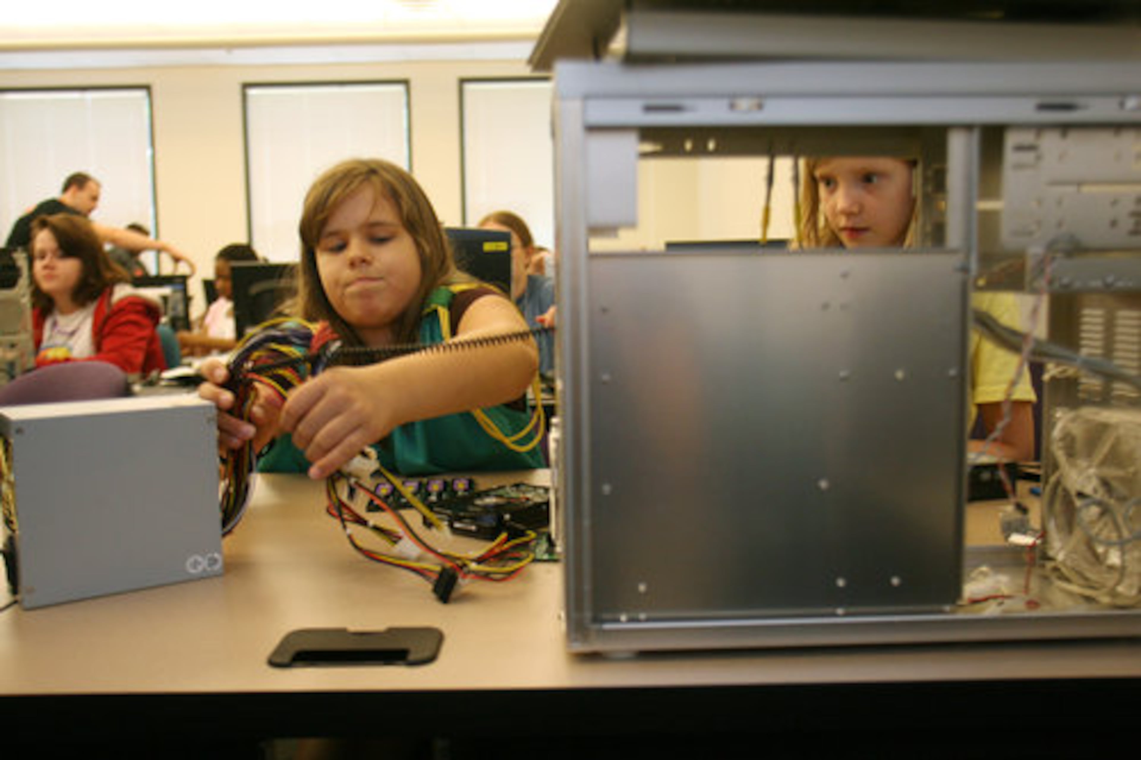 Girl Scouts Sarah Schurr, 10, (left) and Anne Marie McCormick, 11, identify the power supply to the computer they will assemble in a PC building class.