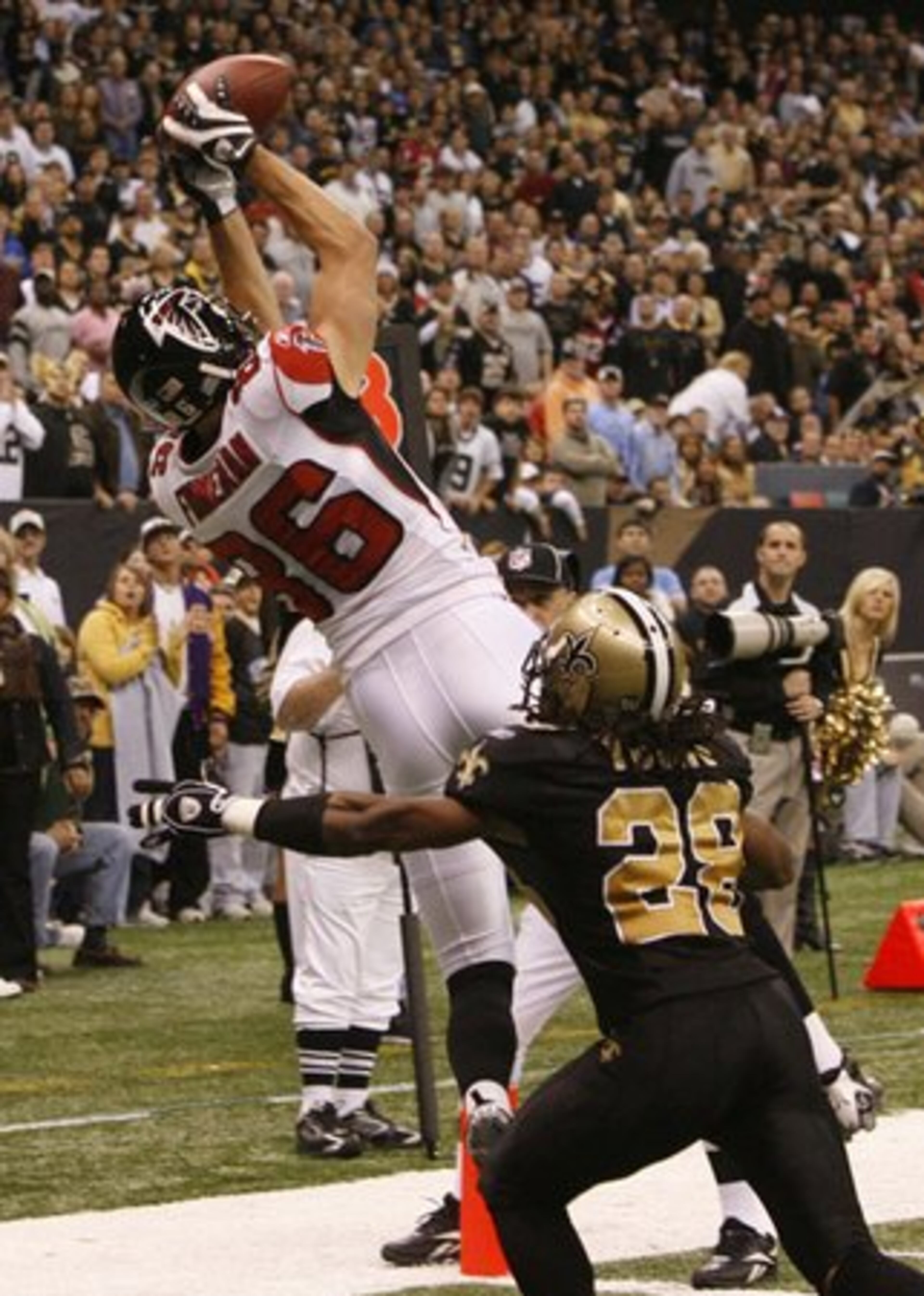 Wide receiver Brian Finneran goes over Saints cornerback Usama Young on a 2-yard pass from Matt Ryan with just over two minutes left in the first half. The reception gave the Falcons a 14-13 lead until the Saints kicked a field goal with 3 seconds left before the half.