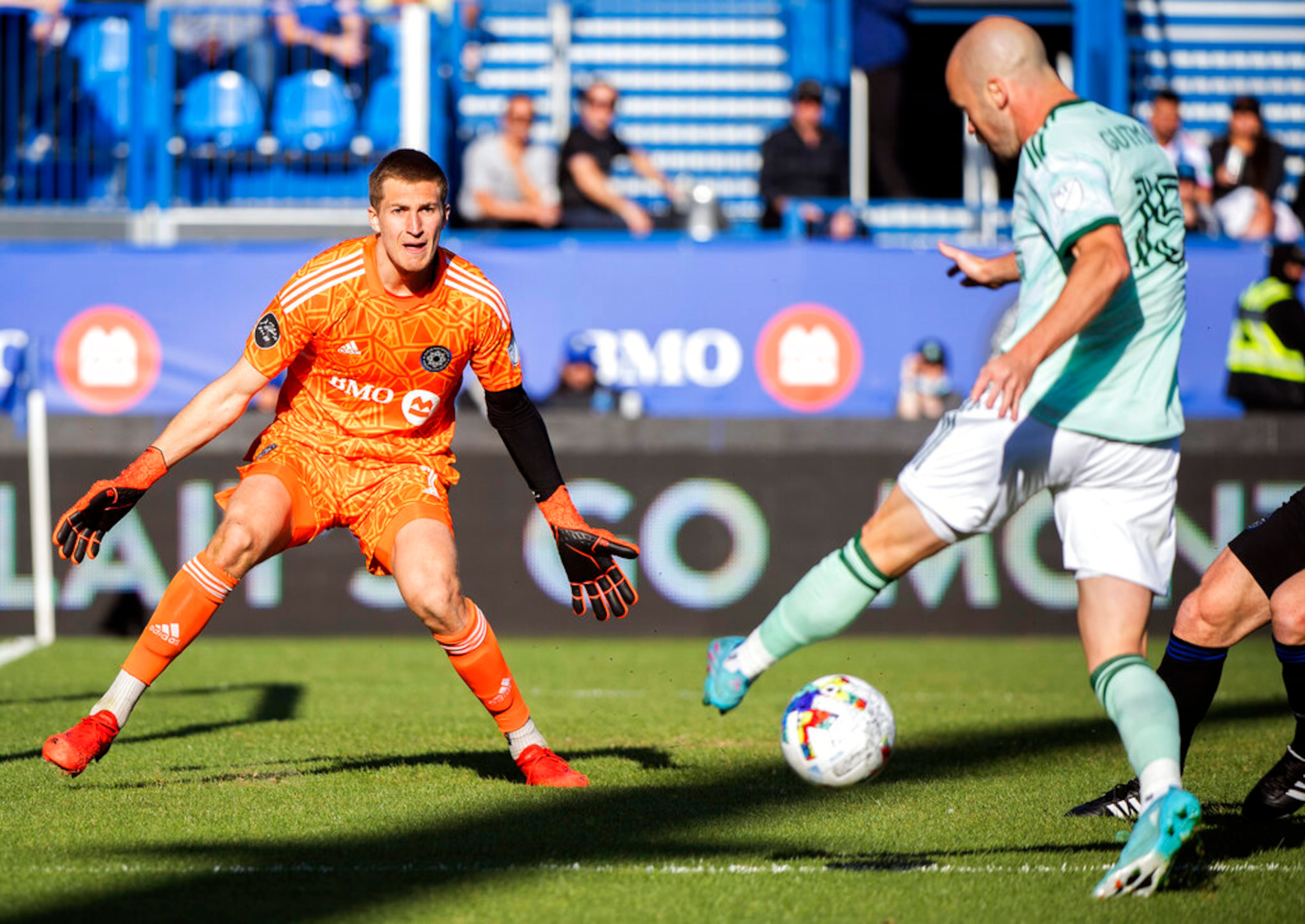 CF Montreal's goalkeeper Sebastian Breza keeps his eyes on the ball as Atlanta United's Andrew Gutman attempts a shot during the second half of an MLS soccer game in Montreal, Saturday, April 30, 2022. (Graham Hughes/The Canadian Press via AP)