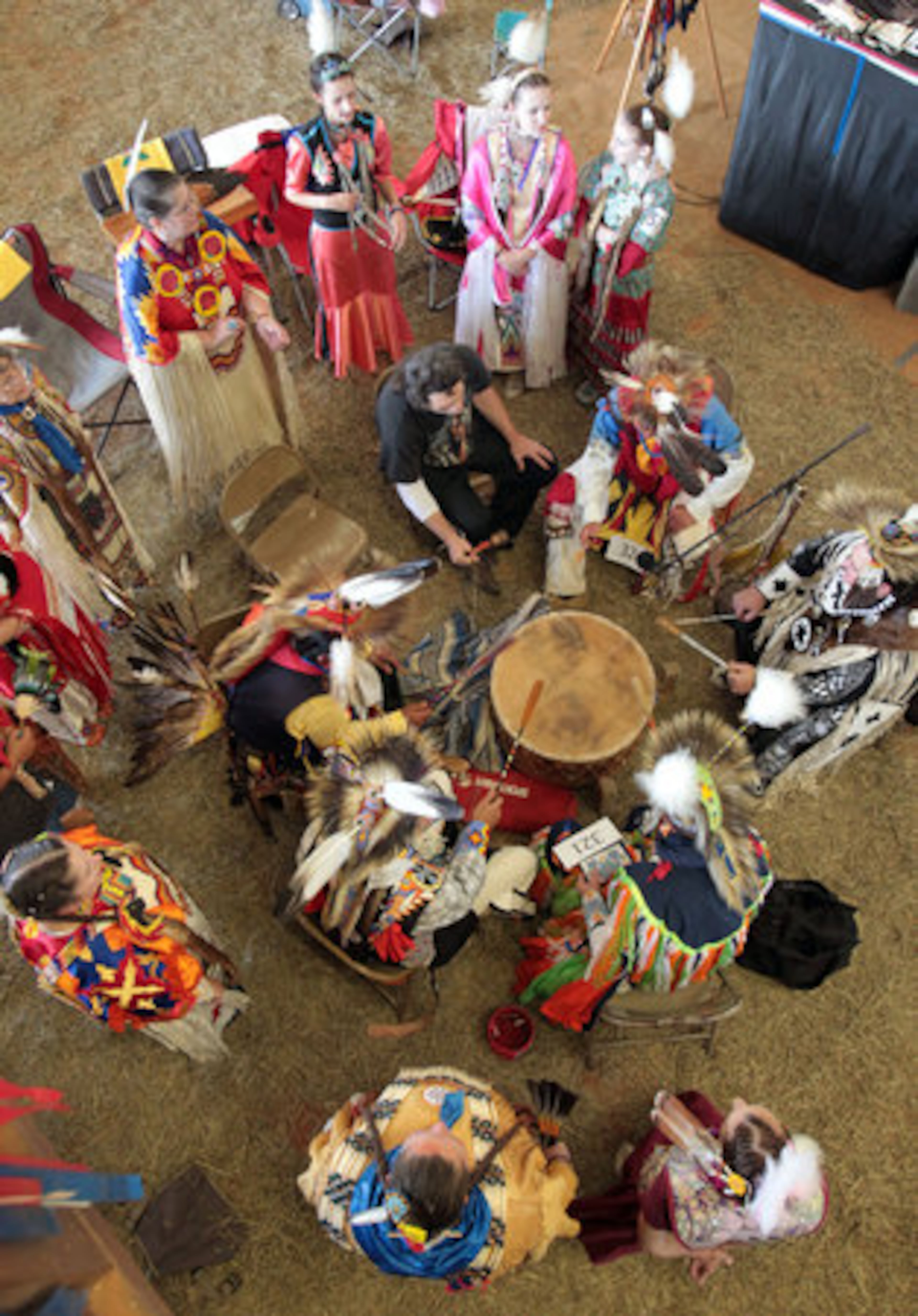 Women circle a group of men singing and drumming during the American Indian Festival grand entry in the covered rodeo arena of the Gwinnett County Fairgrounds Saturday afternoon in Lawrenceville, Ga., May 28, 2011.