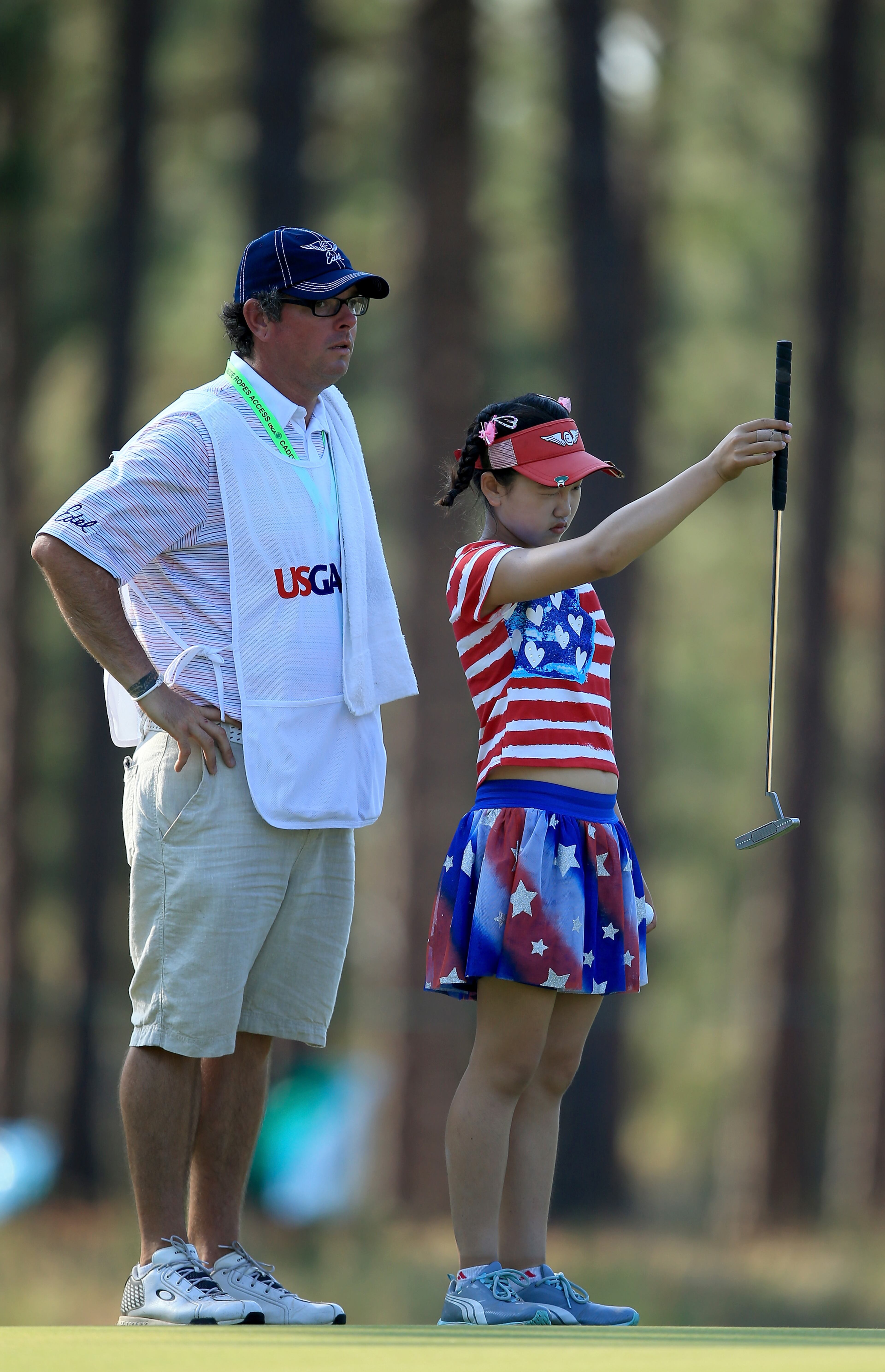 Lucy Li of the USA, who is only 11 years old, lines up a putt at the par 3, 15th hole with her caddie Bryan Bush during the first round of the 69th U.S. Women's Open at Pinehurst Resort & Country Club, Course No. 2 on June 19, 2014 in Pinehurst, North Carolina. (Photo by David Cannon/Getty Images)