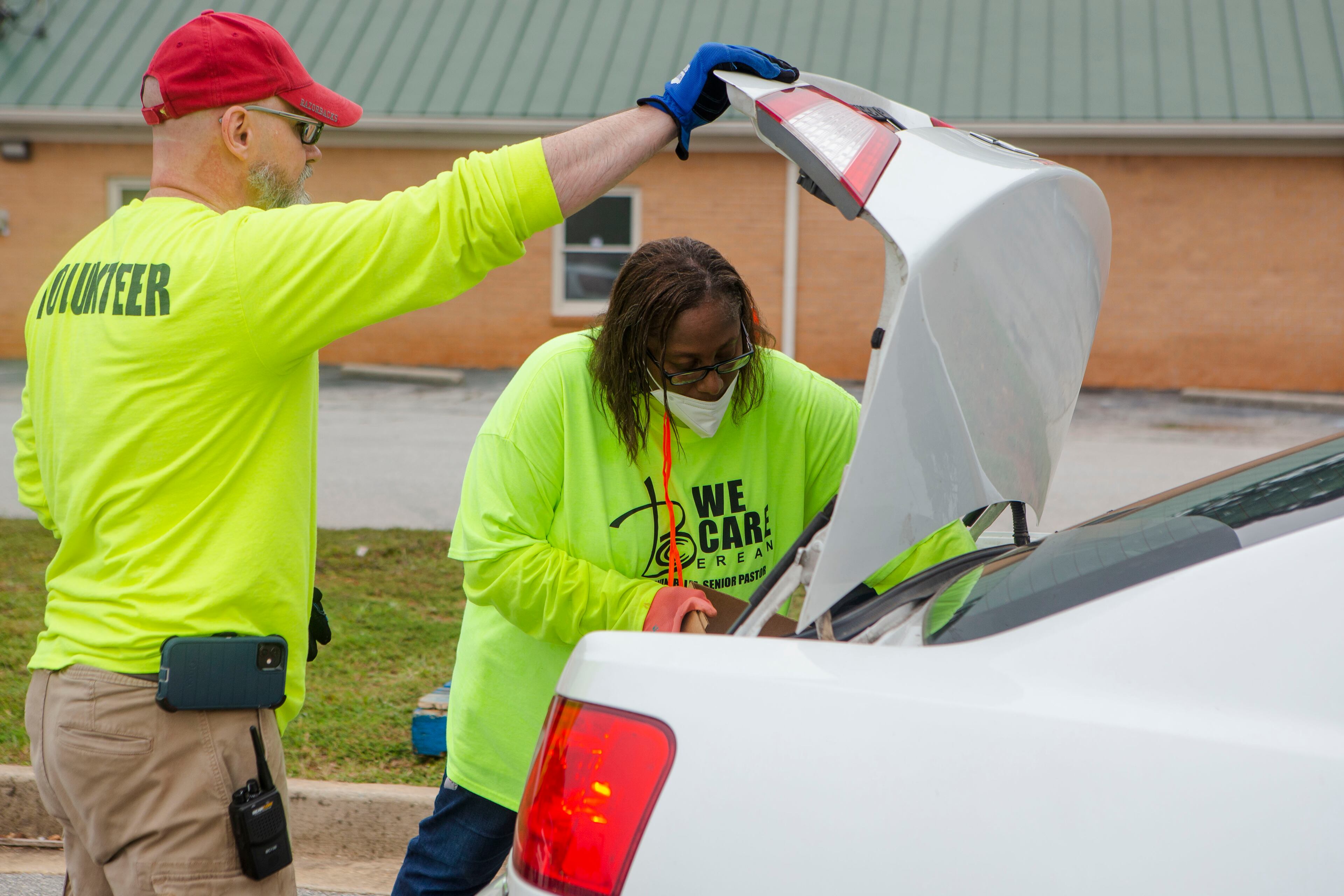 Tomas Kasprzyk (left) and Ora Kaspryzyk (right) load vehicles during a food giveaway event at Berean Christian Church on Saturday, August 27, 2022, in Stone Mountain. The free food was paid for using federal COVID-19 stimulus funds, and was distributed at churches throughout DeKalb County. CHRISTINA MATACOTTA FOR THE ATLANTA JOURNAL-CONSTITUTION.