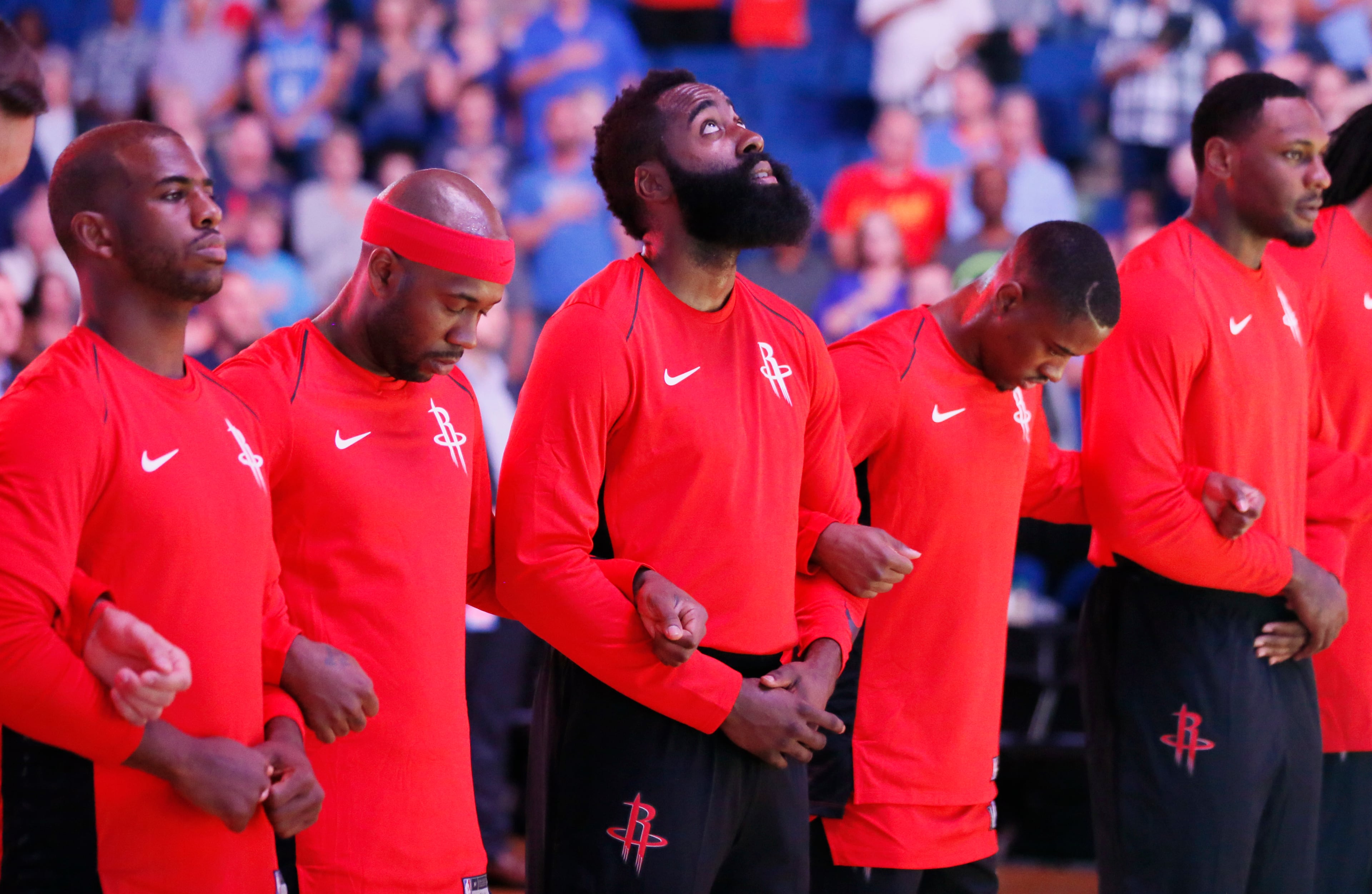 Houston Rockets guard James Harden, center, links arms with his teammates during the playing of the National Anthem before an NBA pre-season basketball game between the Houston Rockets and the Oklahoma City Thunder on Oct. 3.