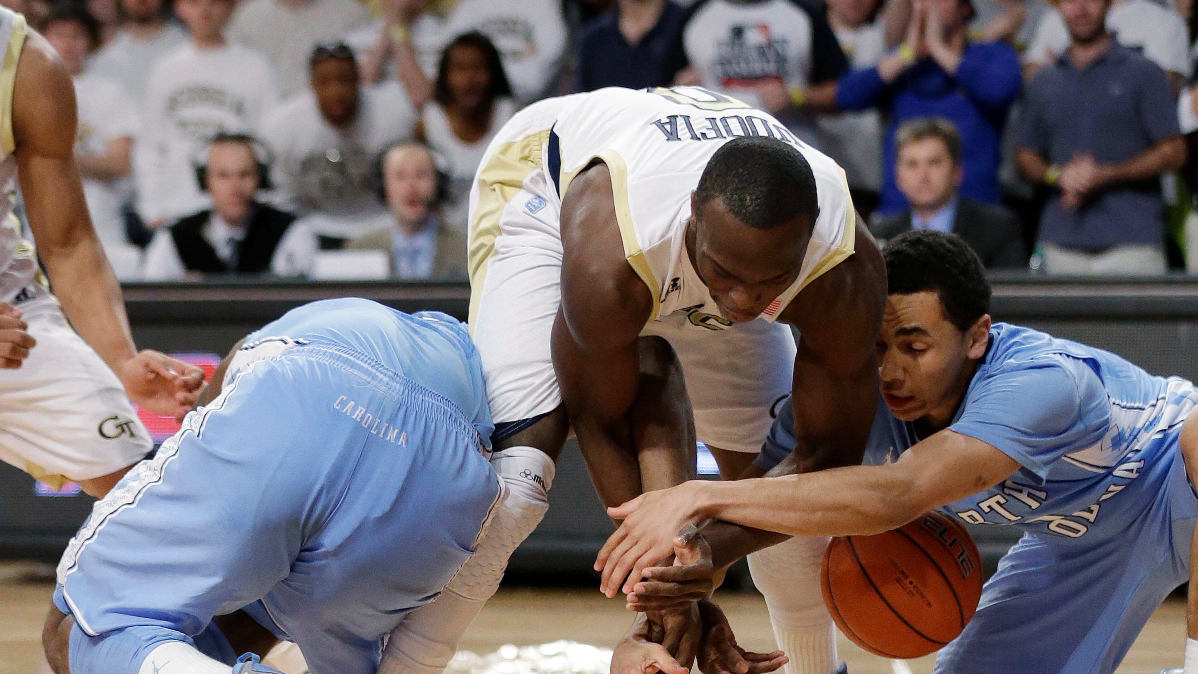 Georgia Tech guard Mfon Udofia scrambles for a lose ball against North Carolina guards Luke Davis, right, and P.J. Hairston. North Carolina won 70-58.