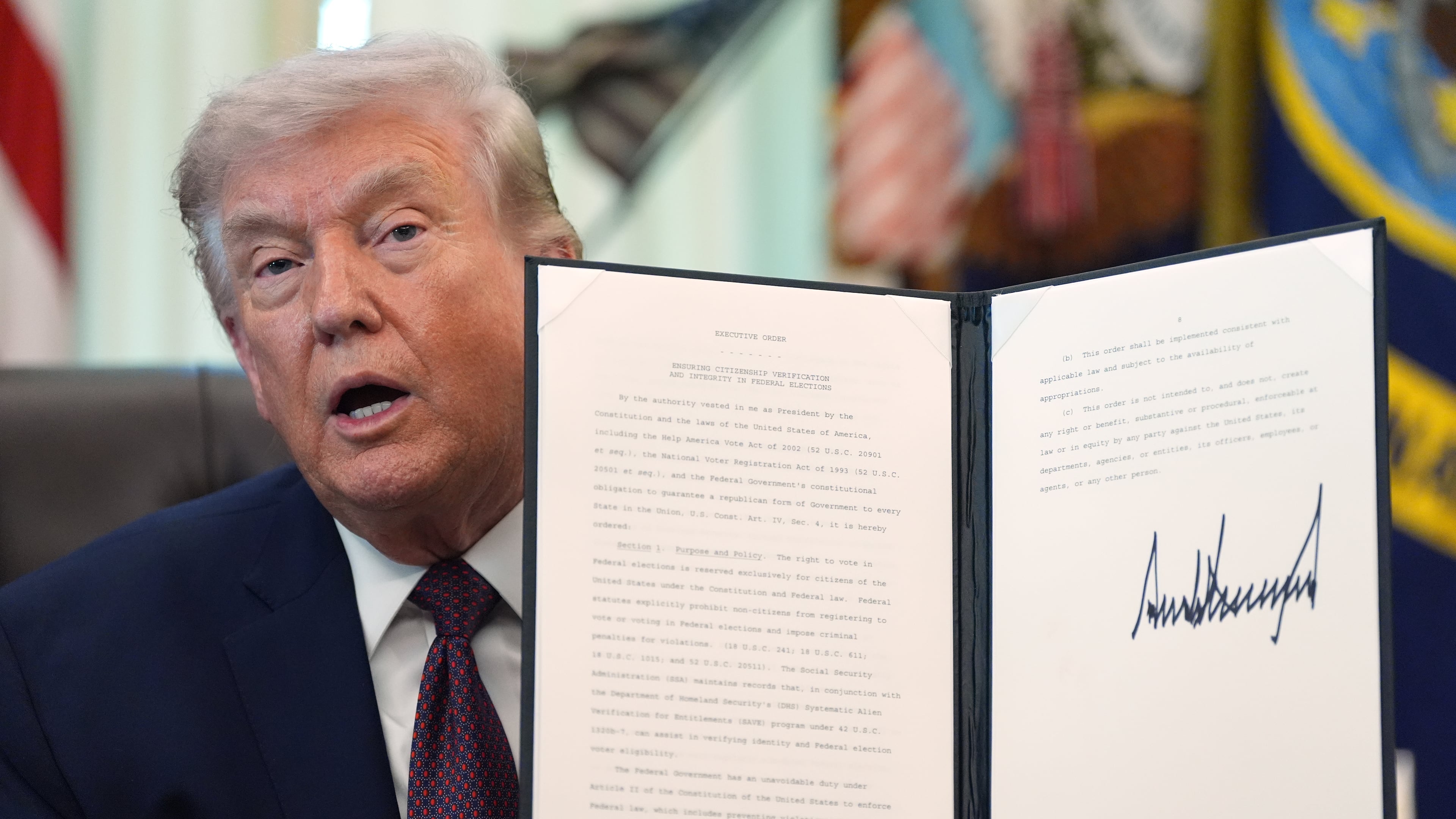 President Donald Trump holds a signed executive order in the Oval Office of the White House Tuesday, March 31, 2026, in Washington. (AP Photo/Alex Brandon)