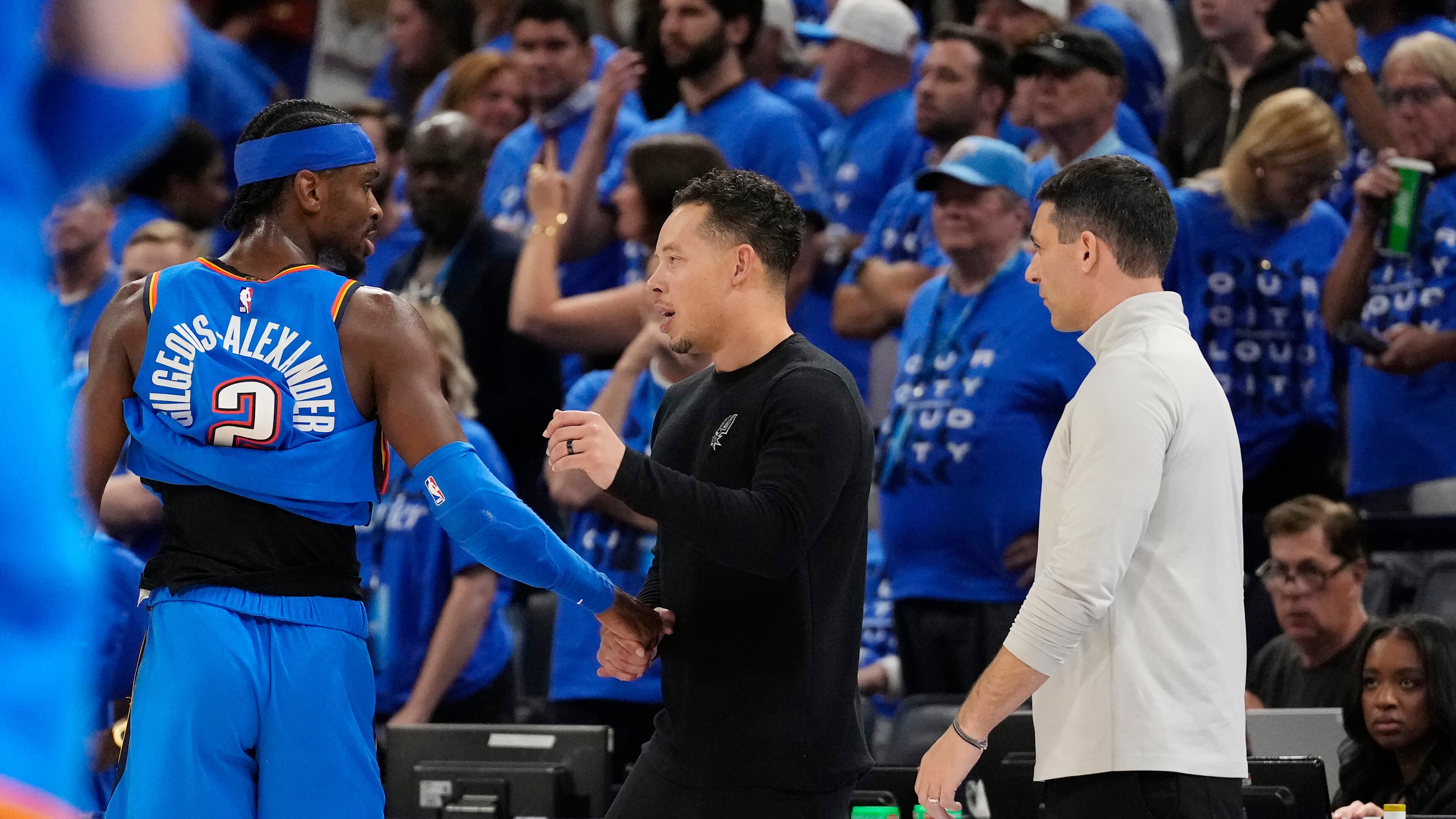 San Antonio Spurs head coach Mitch Johnson, center, talks with Oklahoma City Thunder guard Shai Gilgeous-Alexander (2) as Thunder head coach Mark Daigneault looks on during the second half of Game 7 of the Western Conference finals of the NBA basketball playoffs series Saturday, May 30, 2026, in Oklahoma City. (AP Photo/Tony Gutierrez)