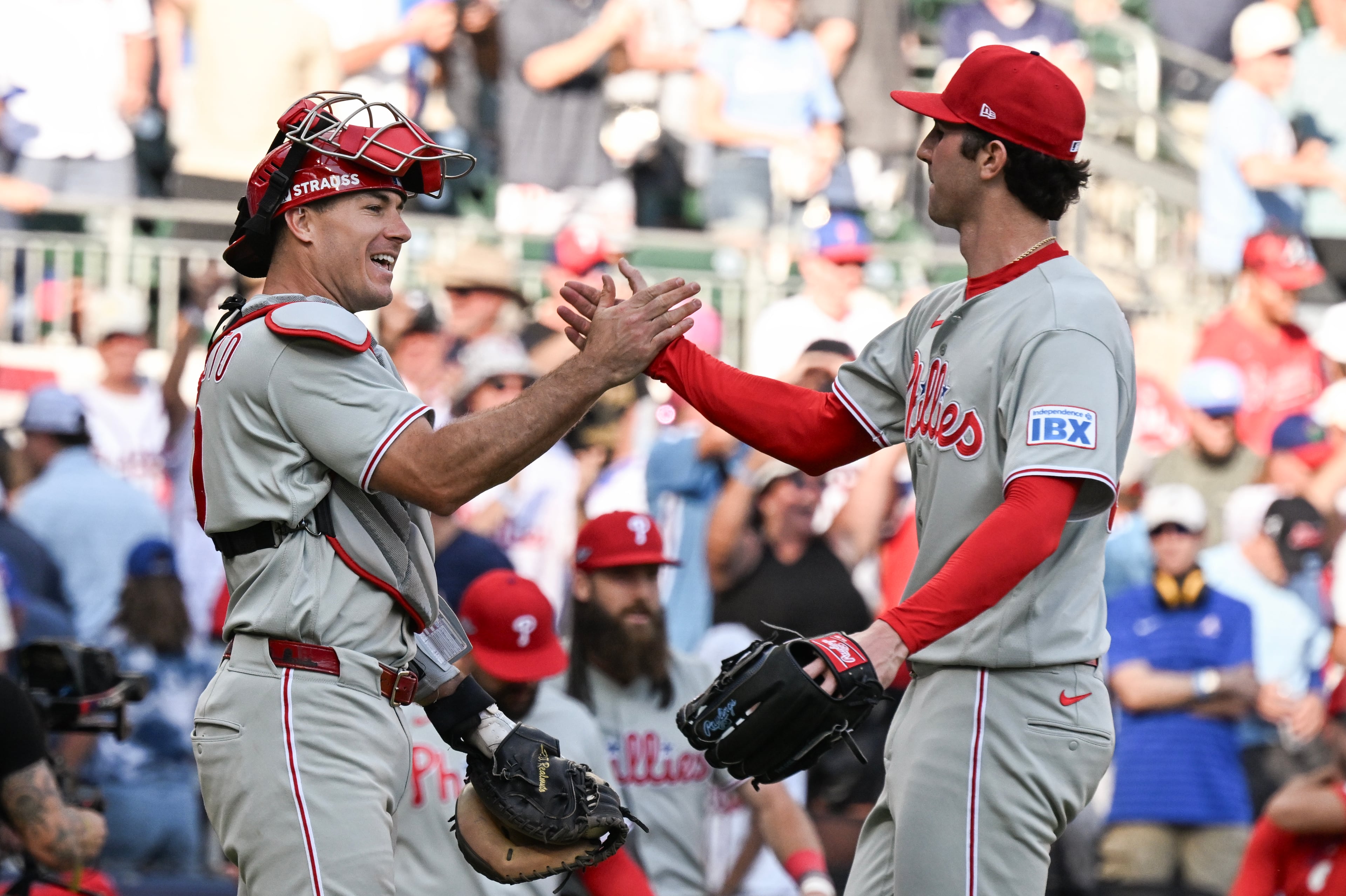 Phillies catcher J.T. Realmuto (left) celebrates with pitcher Andrew Painter after defeating the Braves in extra innings during Game 2 of their NL Wild Card Series on Wednesday, Sept. 30, 2026, in Atlanta. (Hyosub Shin/AJC)