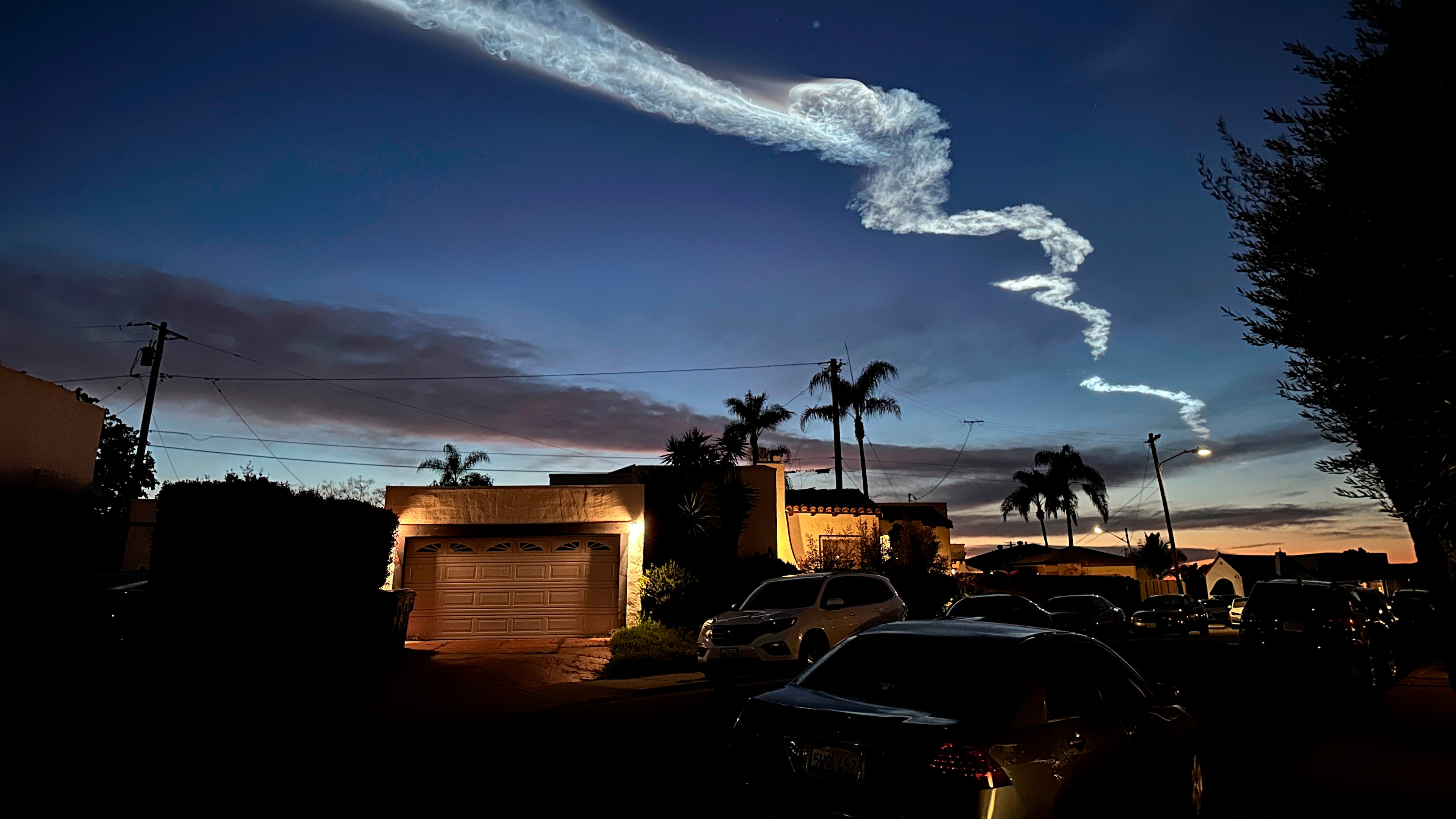 FILE - A contrail from a SpaceX Falcon 9 rocket, which launched from Vandenberg Space Force Base, is seen over homes March 18, 2024, in San Diego. (AP Photo/Gregory Bull, File)