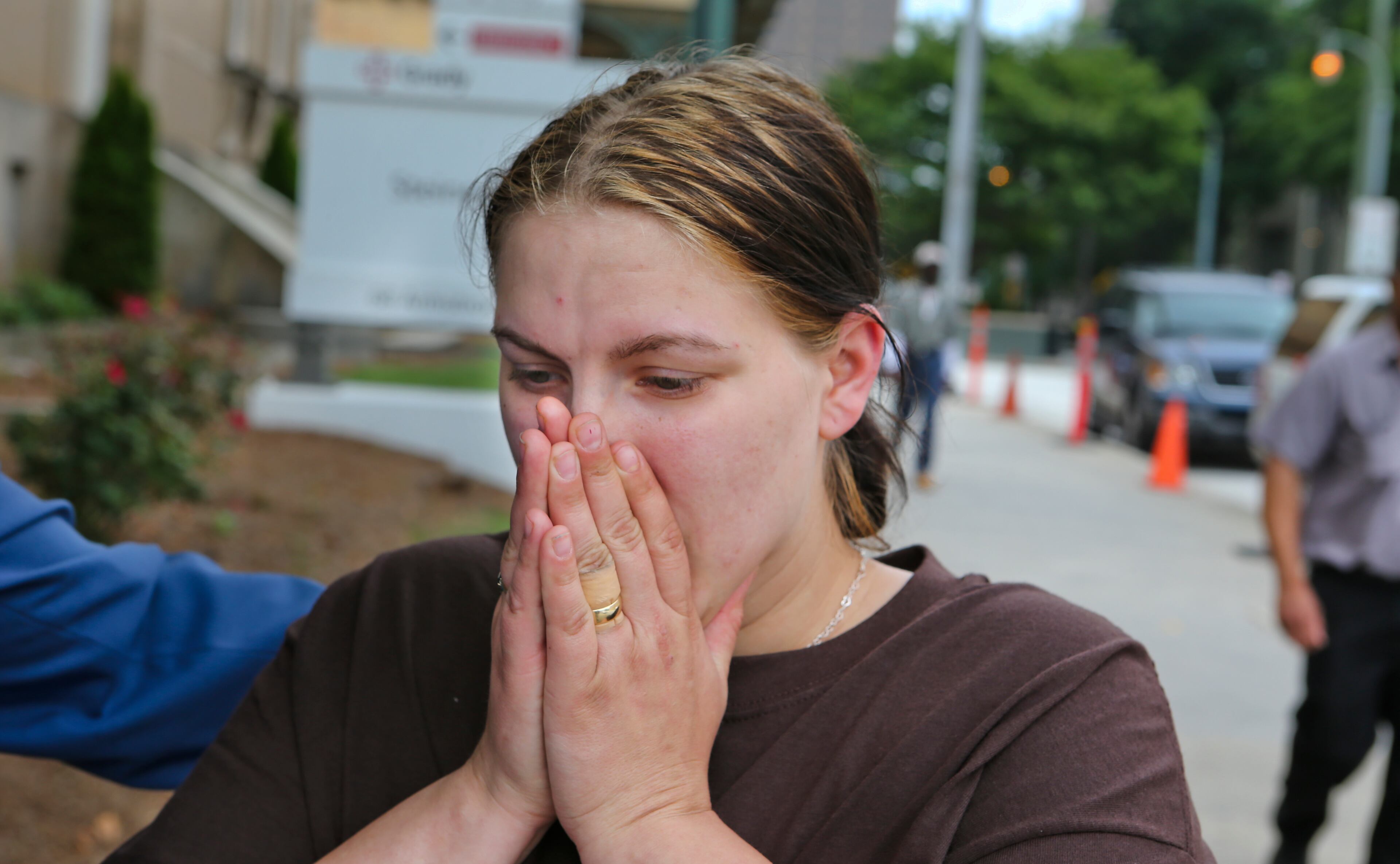 Alecia Phonesavanh pauses to compose herself outside Grady Memorial Hospital on Friday as she discusses how her 19-month-old son was critically injured in a police raid this week.