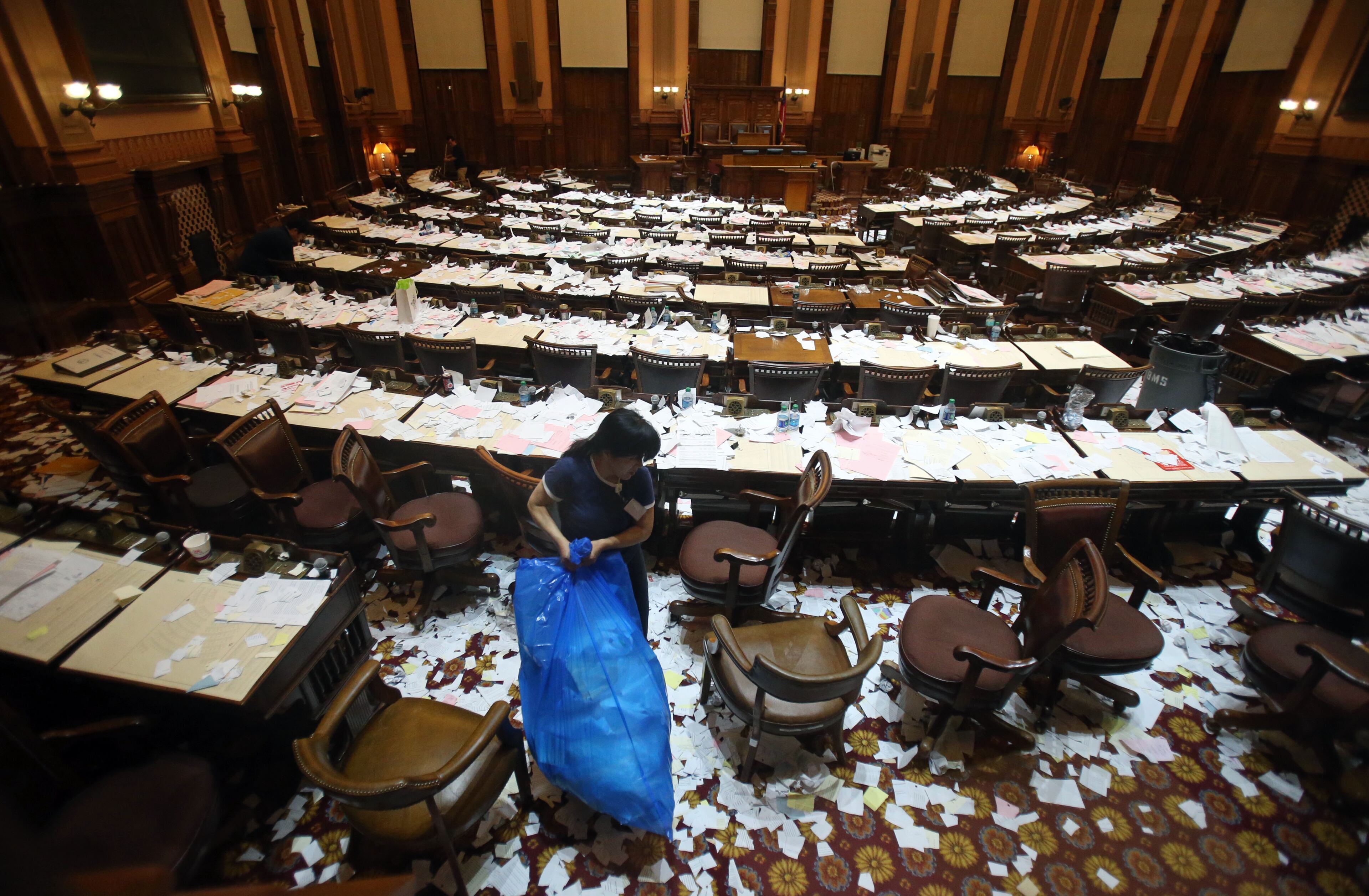 Myonz Kown, an employee with Building Maintenance Service, begins the cleanup following, "Sine Die," in the House Chamber after the final day of the 2013 Legislative Session at the Capitol Thursday night in Atlanta, Ga., March 28, 2013.