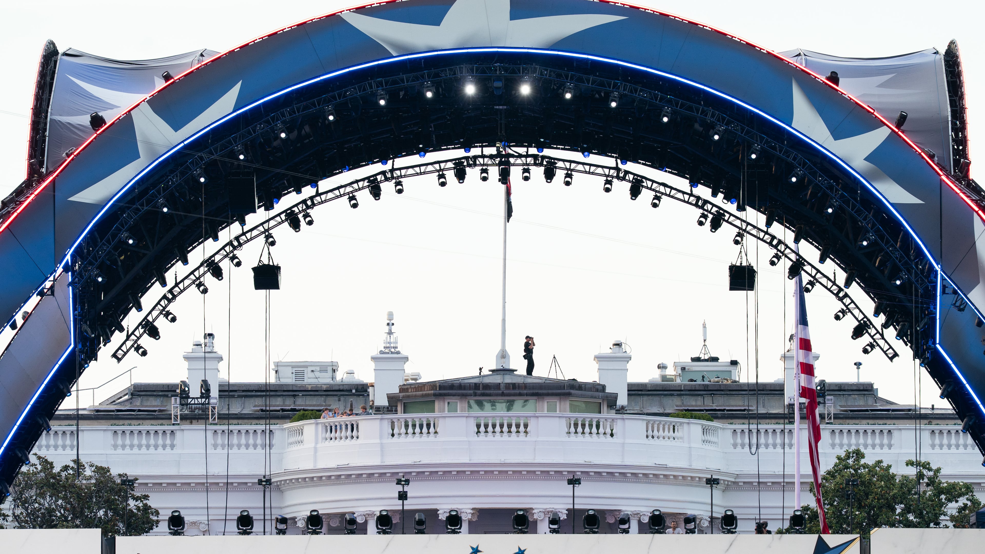 Security at the White House looks through a pair of binoculars during the UFC Fan Fest on the White House Ellipse ahead of Sunday's fight on the South Lawn, Saturday, June 13, 2026, in Washington. (AP Photo/Allison Robbert)