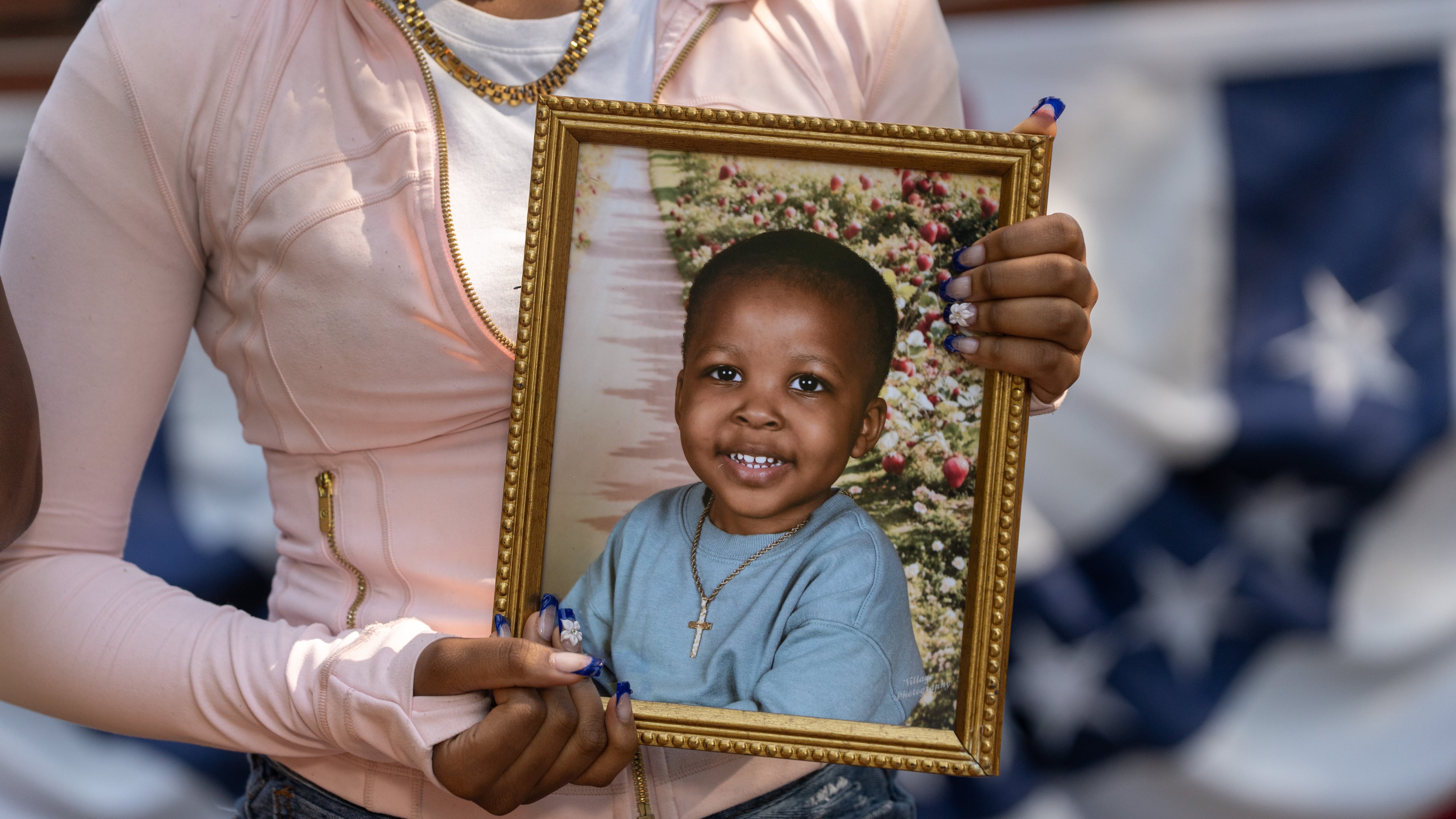 A family member holds a framed photograph of Messiah Harris, a 2-year-old boy found dead in Marietta, during a news conference in Marietta Square on Wednesday, Aug. 12, 2026. (Ben Hendren for the AJC)