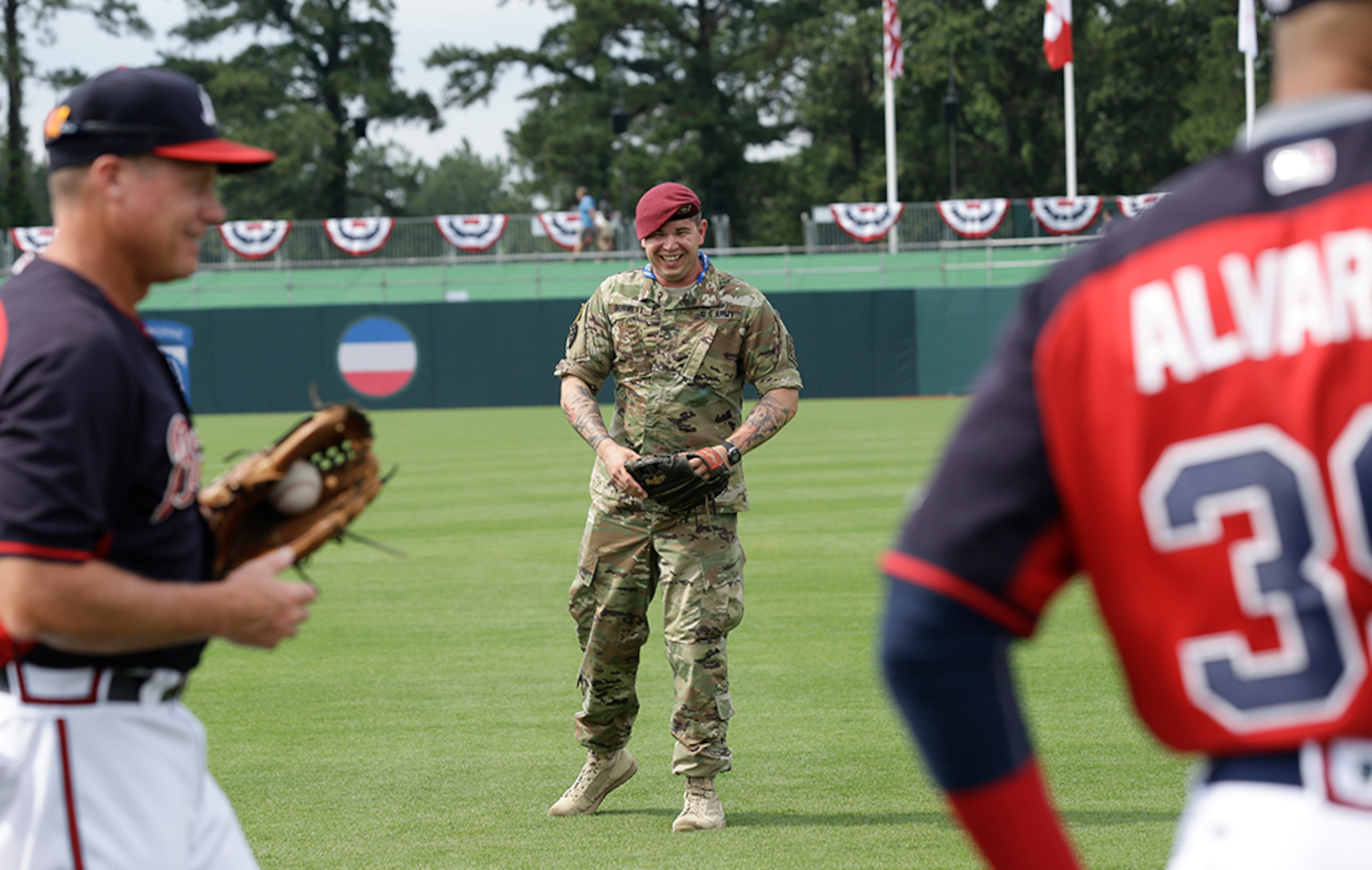U.S. Army Sgt. Alex Burnett of the 82nd Airborne Division throws the ball with Atlanta Braves assistant bullpen coach Alan Butts (left) prior to a baseball game against the Miami Marlins in Fort Bragg, N.C., Sunday, July 3, 2016. The event marks the first regular season game of a professional sport ever played on an active military base, the first of it's kind in celebration of the nation's servicemen and servicewomen.