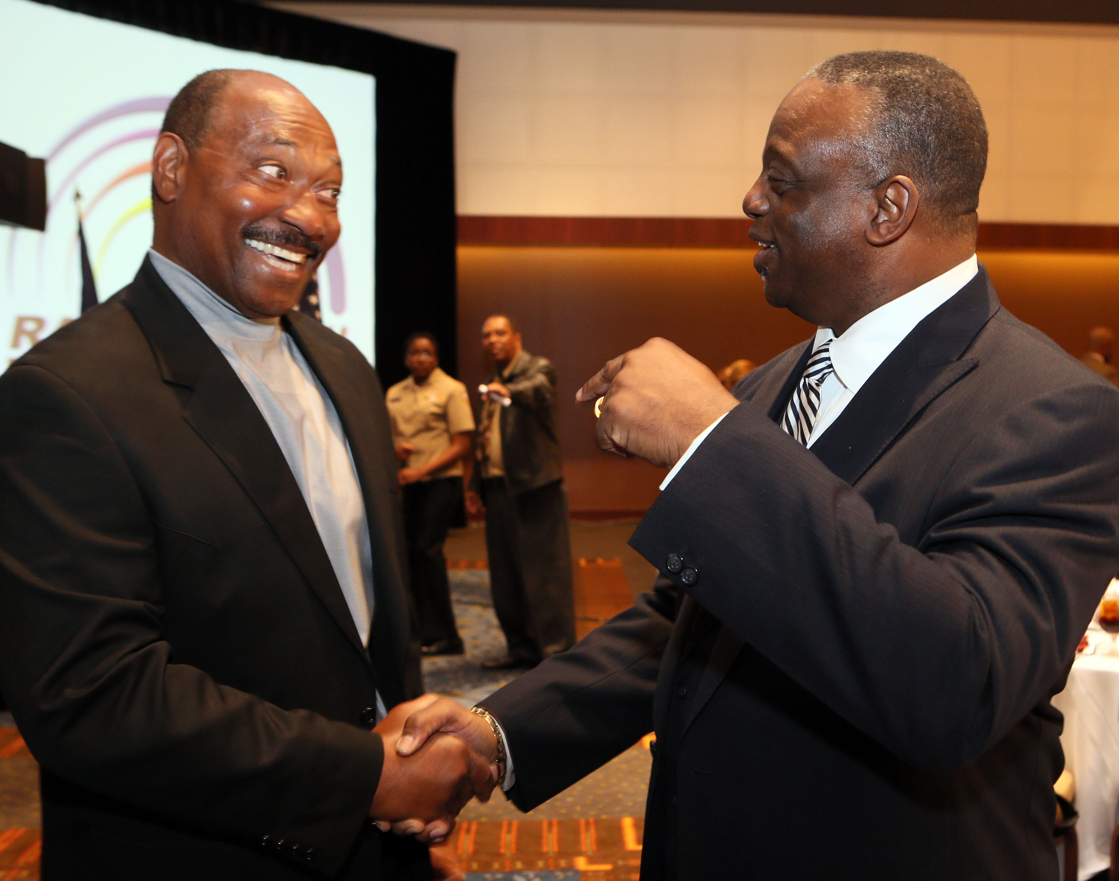 Horace King (left) greets fellow honoree Larry West before a ceremony where the Rainbow PUSH Coalition honored five alumni of the University of Georgia who were the first black students to play football on scholarship at the institution during the Sports Awards Luncheon and Youth Talent Showcase at the Hyatt Regency in Atlanta on Saturday November 2nd, 2013. The players were reunited with their former coach, Vince Dooley, who presented their awards.